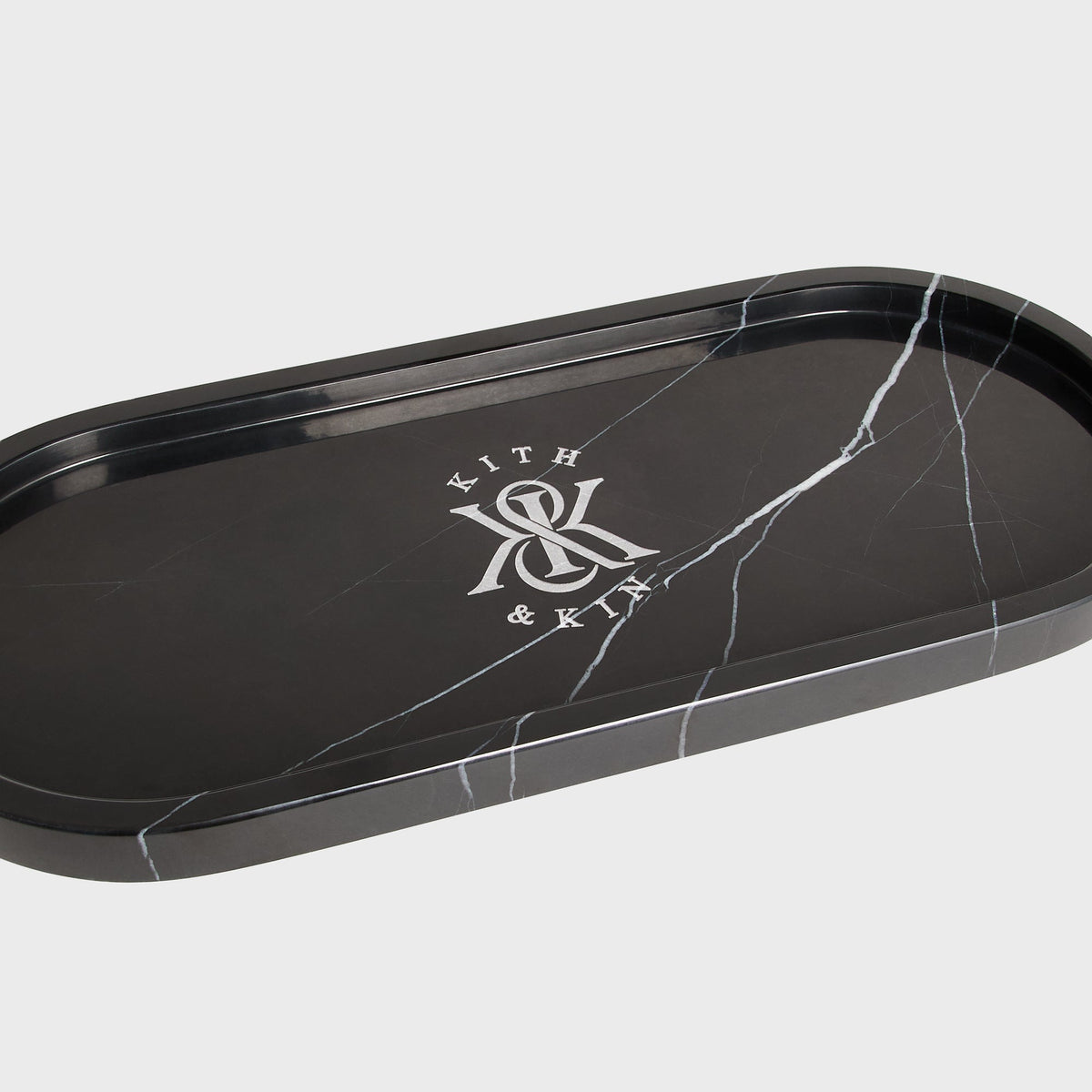 Close-up of Kith & Kin logo and white veining on black marble tray