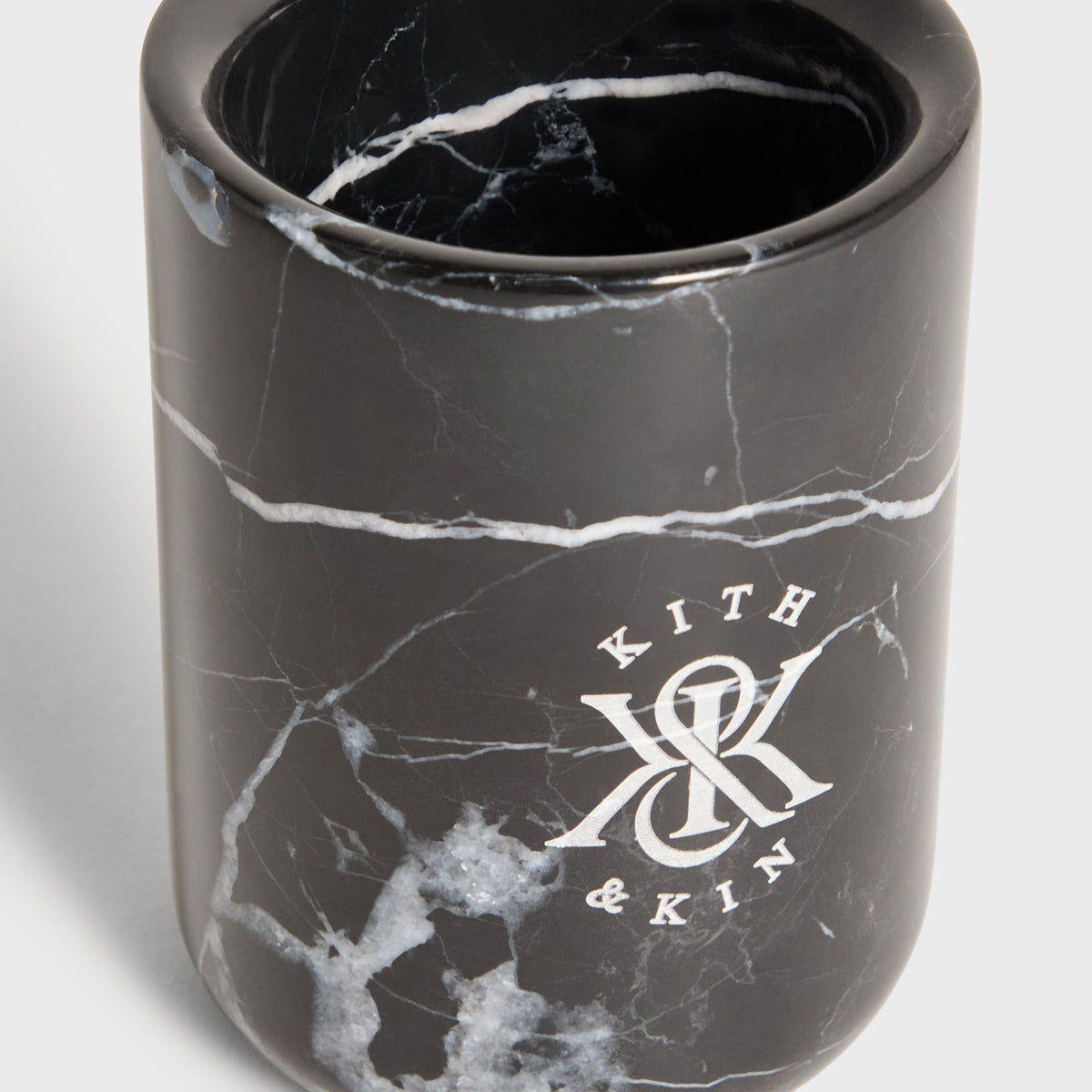 Close-up of Kith & Kin logo and white veining on black marble tumbler