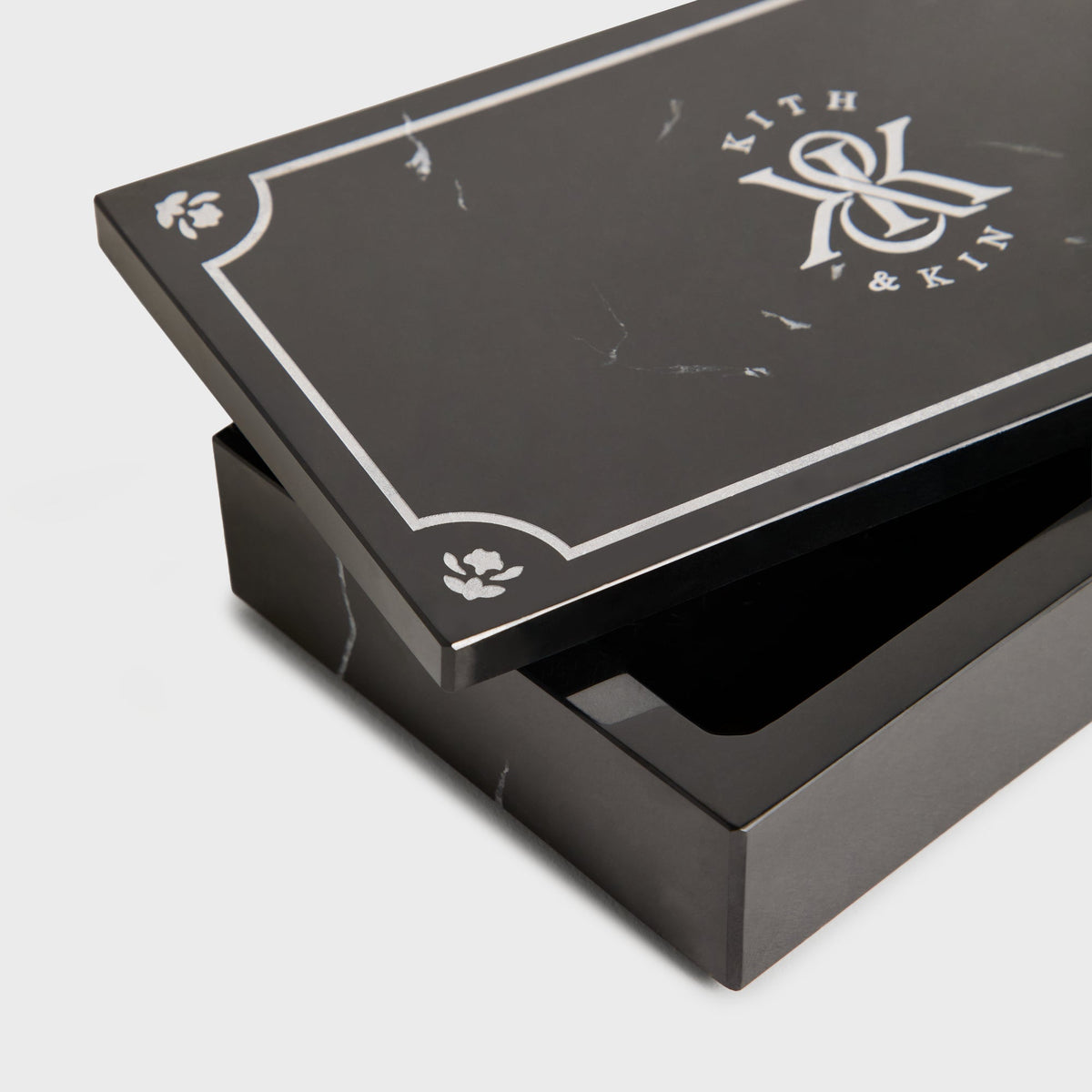 Close-up of black Kith marble box with lid ajar showing interior