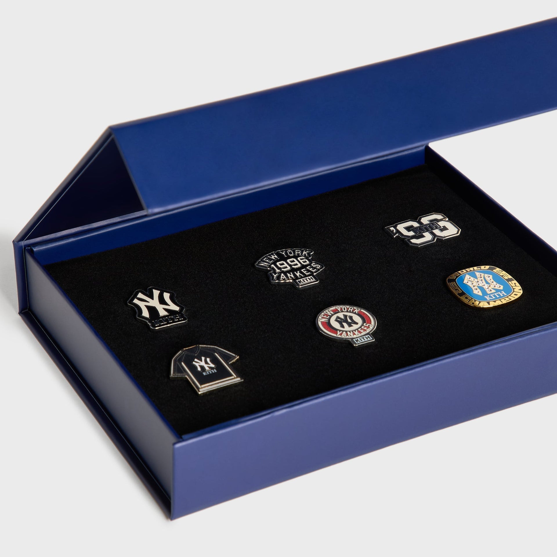 Kith x New York Yankees pin set displayed at an angle inside the open navy gift box