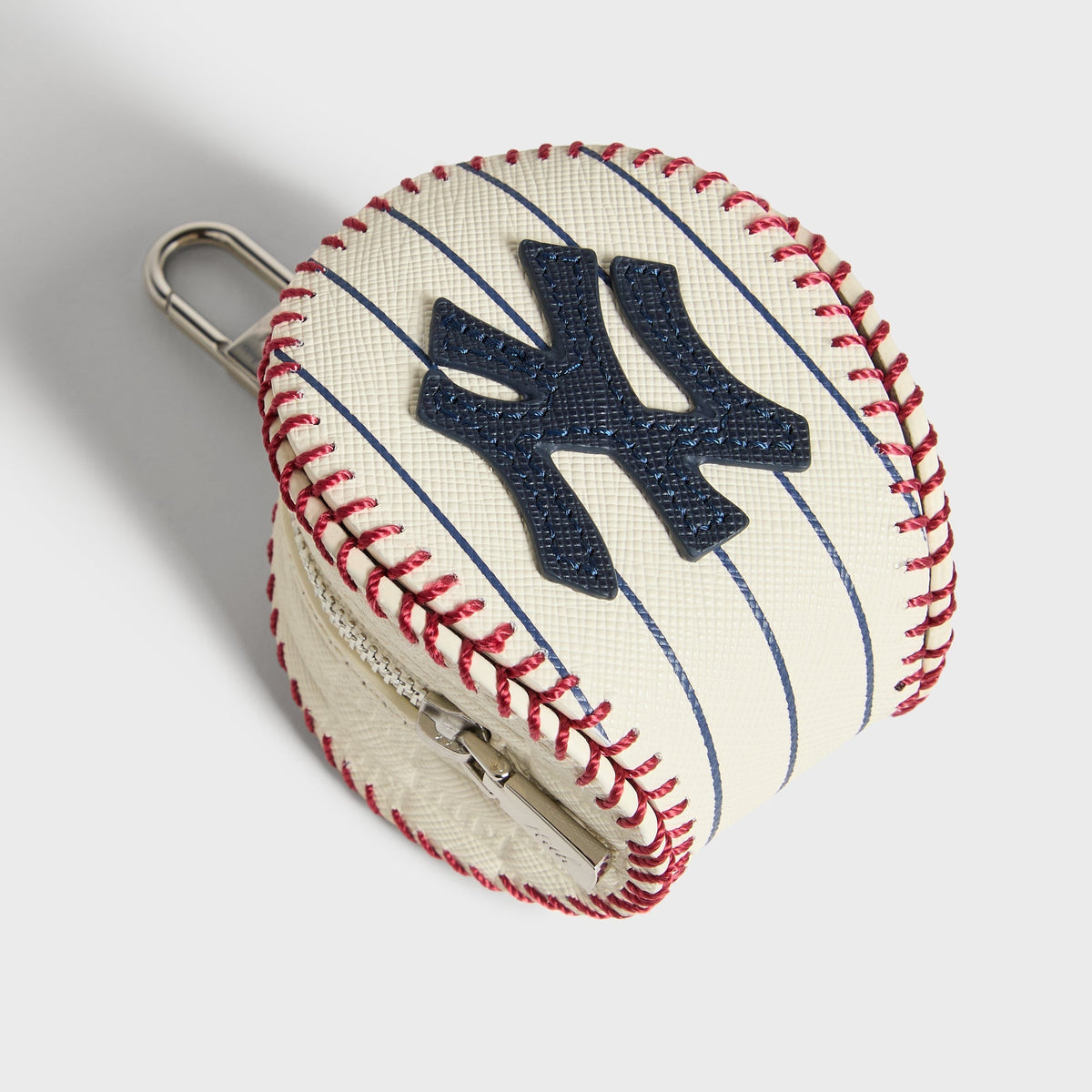 Angled view of the Sandrift leather baseball pouch showing the zipper and red stitched seams