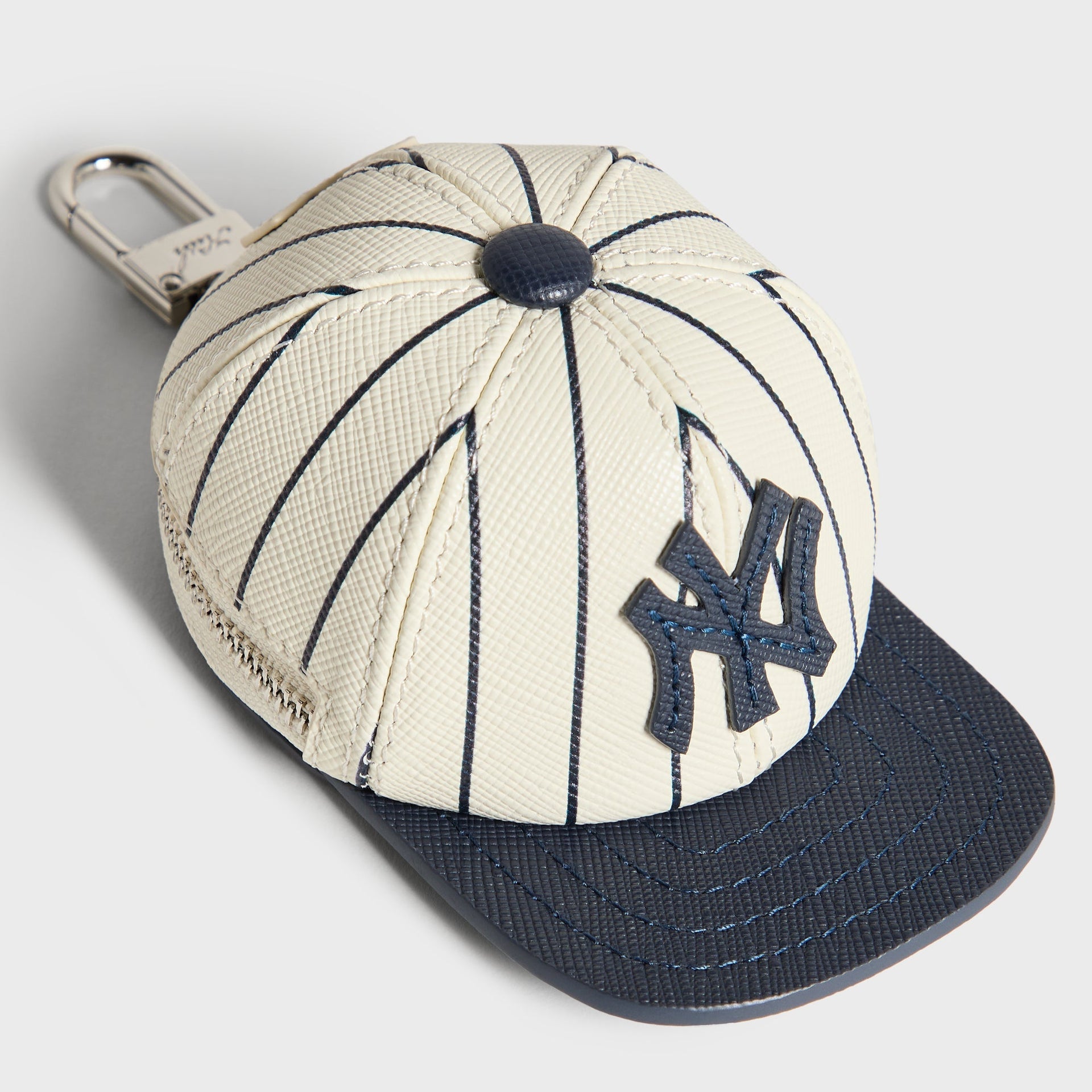 Kith x Yankees Baseball Cap Leather Pouch, Sandrift - 3/4 angle showing NY logo patch and zip closure