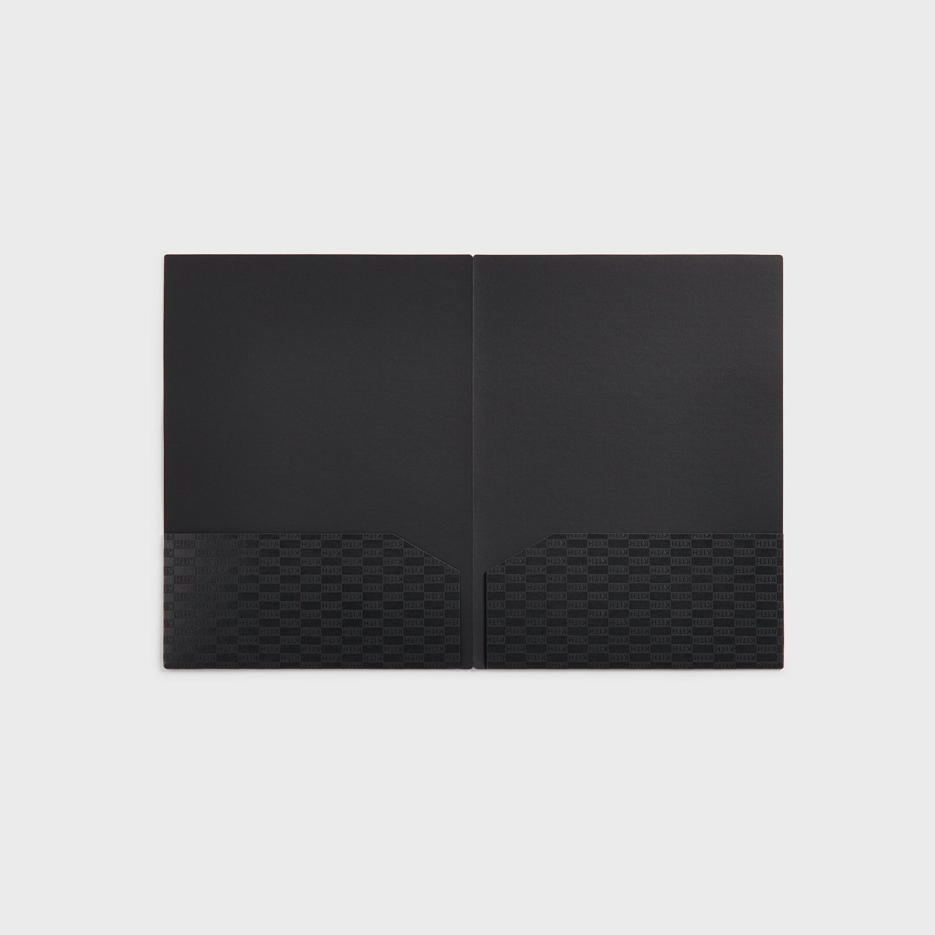 Open black Kith Kids two-pocket folder with tonal monogram pockets, interior view