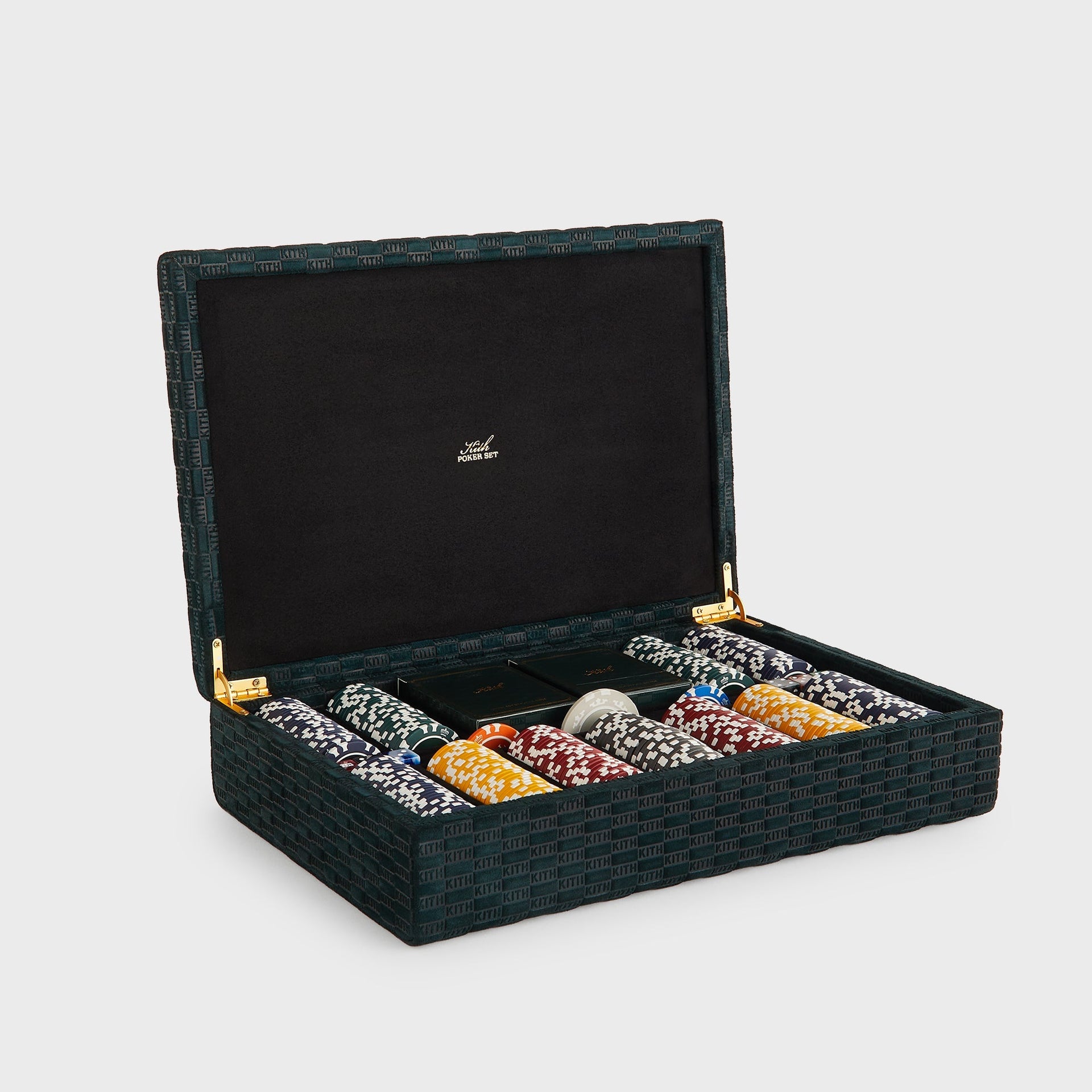 Three-quarter view of the open Kith Poker Set in Stadium green suede, full chip rows, twin card decks and colored dice