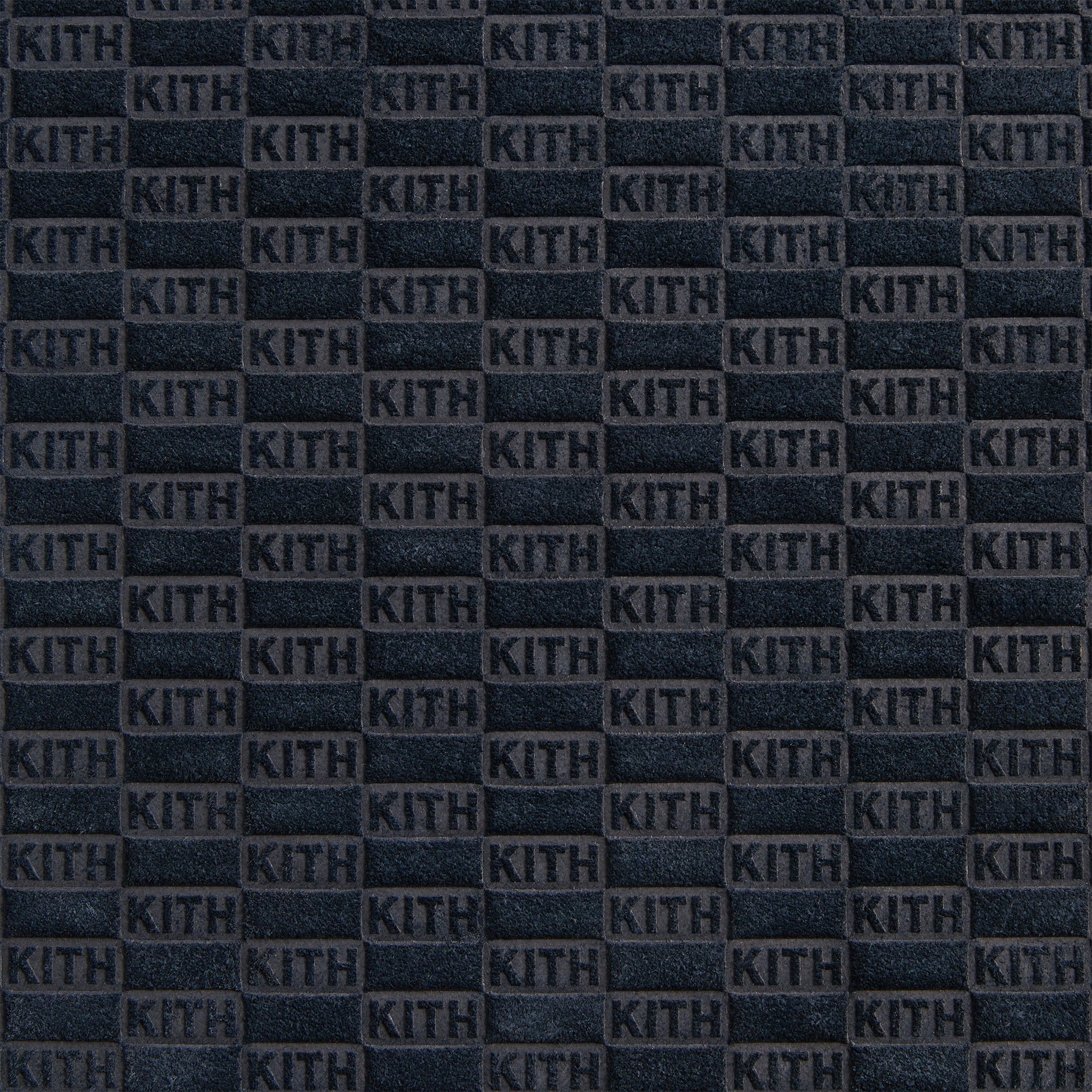 Extreme close-up of the ink suede with allover embossed KITH checkerboard monogram on the Kith backgammon case