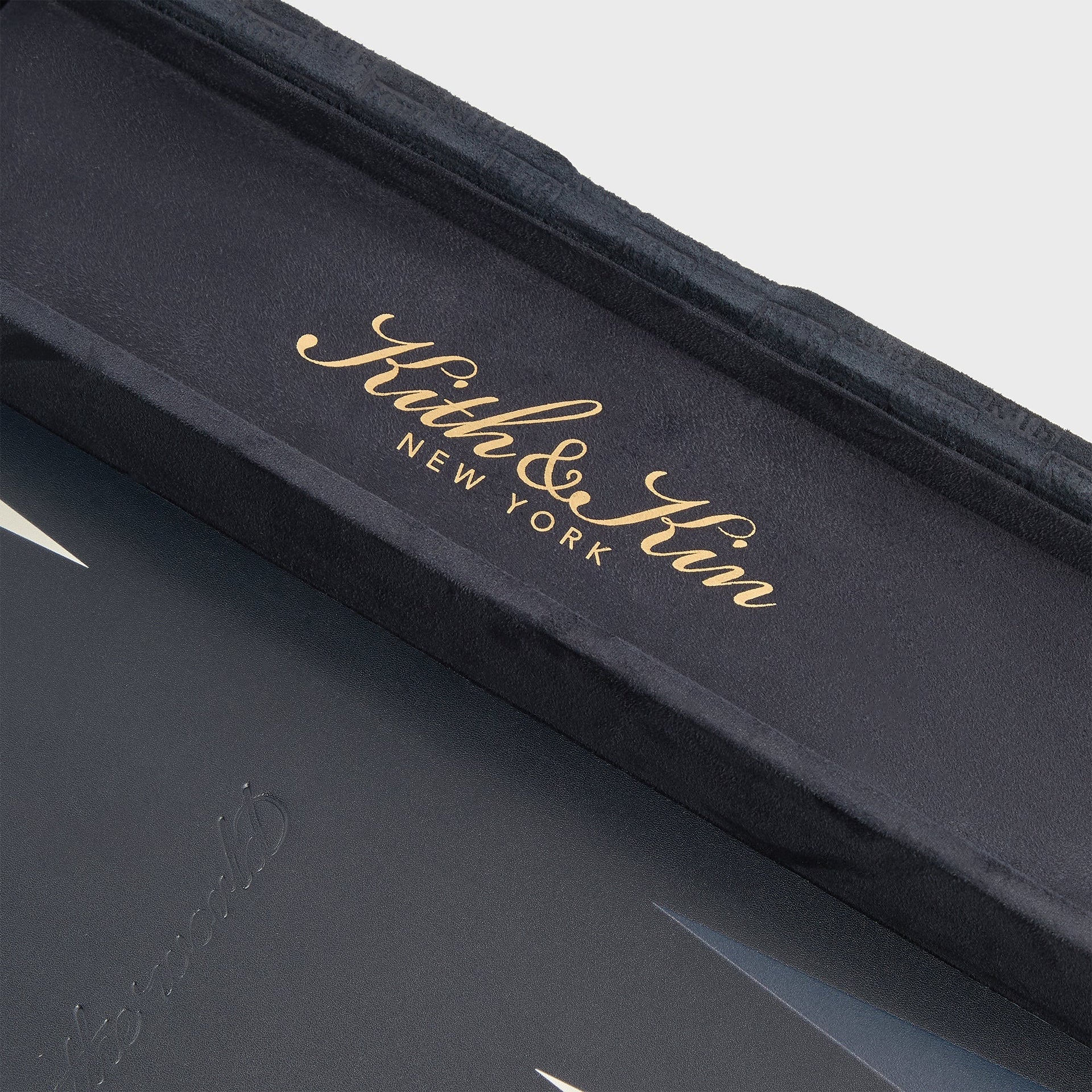 Ink suede interior lid of the Kith & Kin backgammon set with gold-foil Kith & Kin New York script, close detail