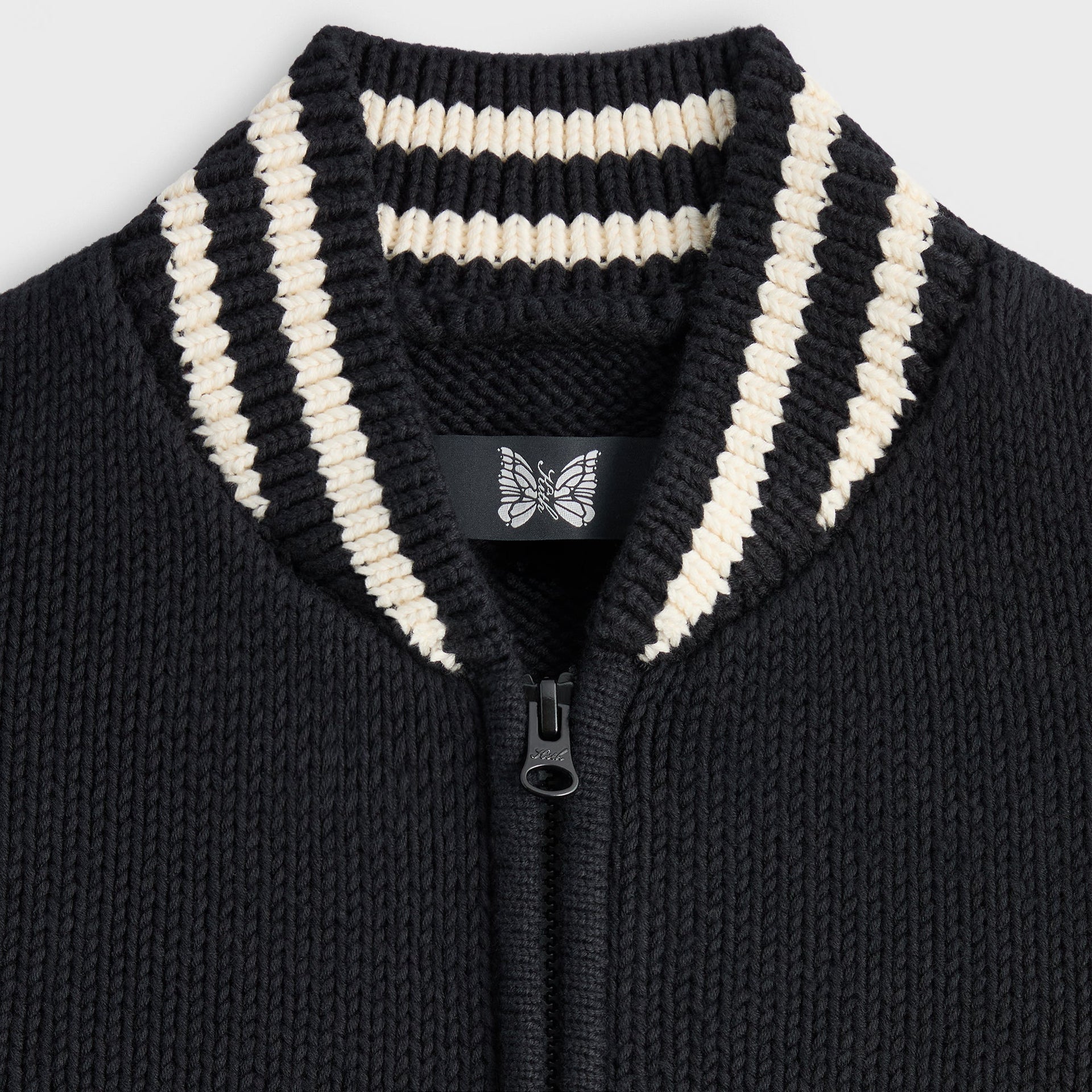 Close-up of the striped collar and butterfly patch on the Kith for Needles Wyona full zip sweater