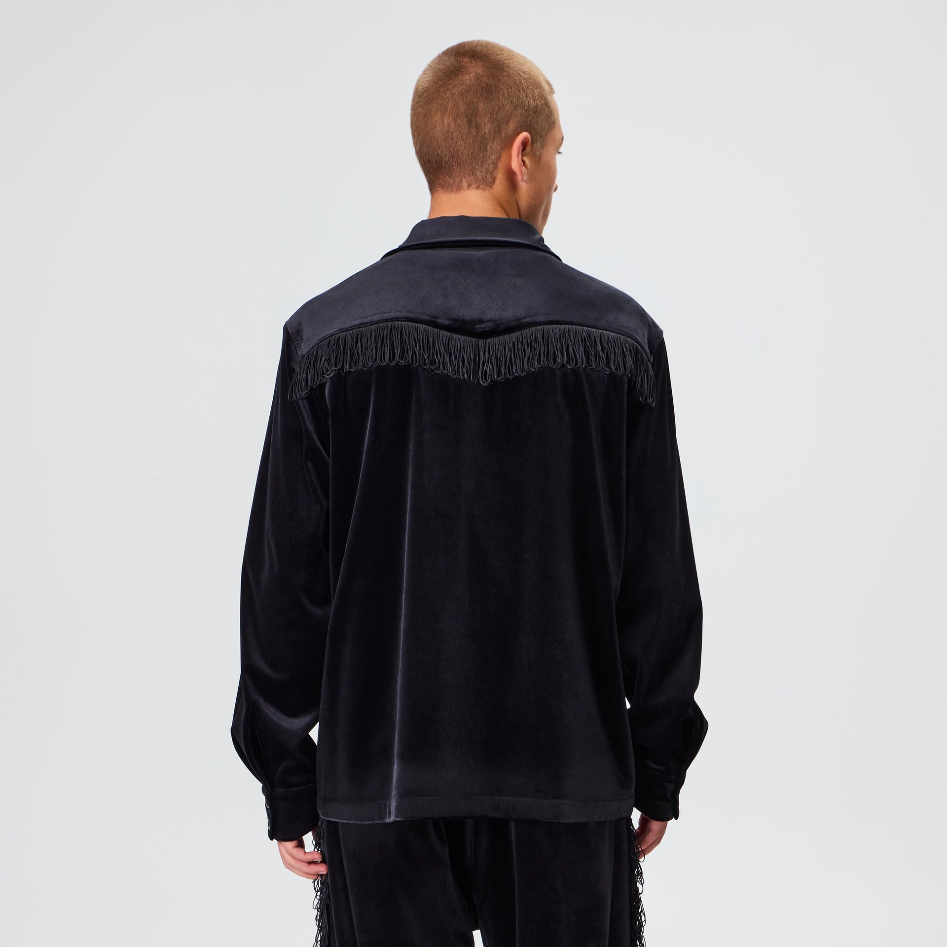 Man wearing the Kith for Needles Ren fringe camp collar shirt in black velour, back view showing fringe yoke