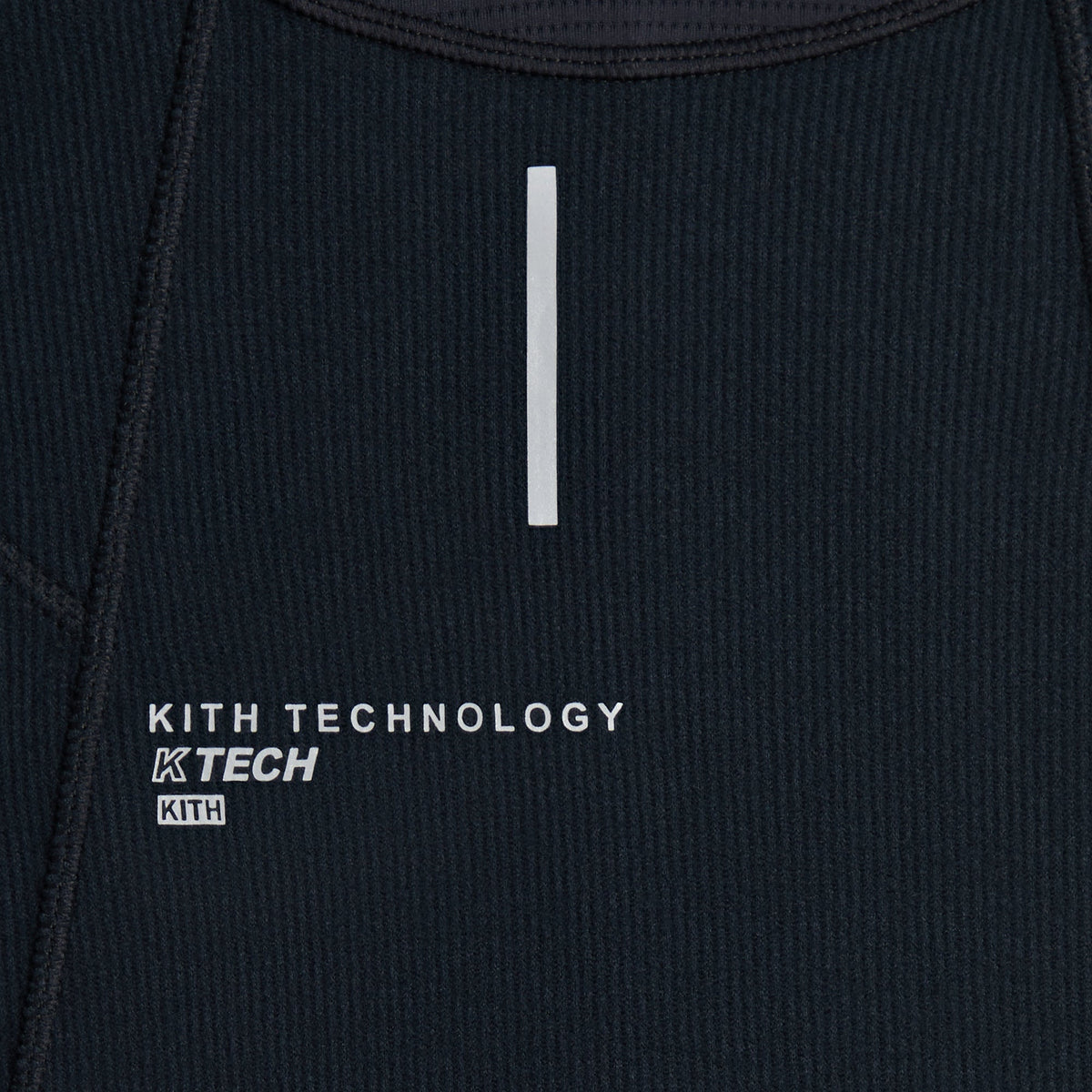 Close-up of Kith Calix Quarter Zip hem reading Kith Technology KTECH near reflective cuff tab