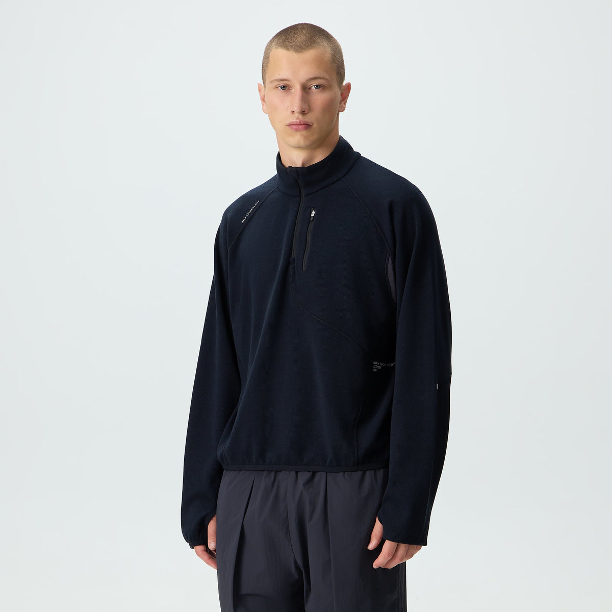 Man modeling Kith Calix Quarter Zip in navy ribbed fleece over matching sweatpants, front view