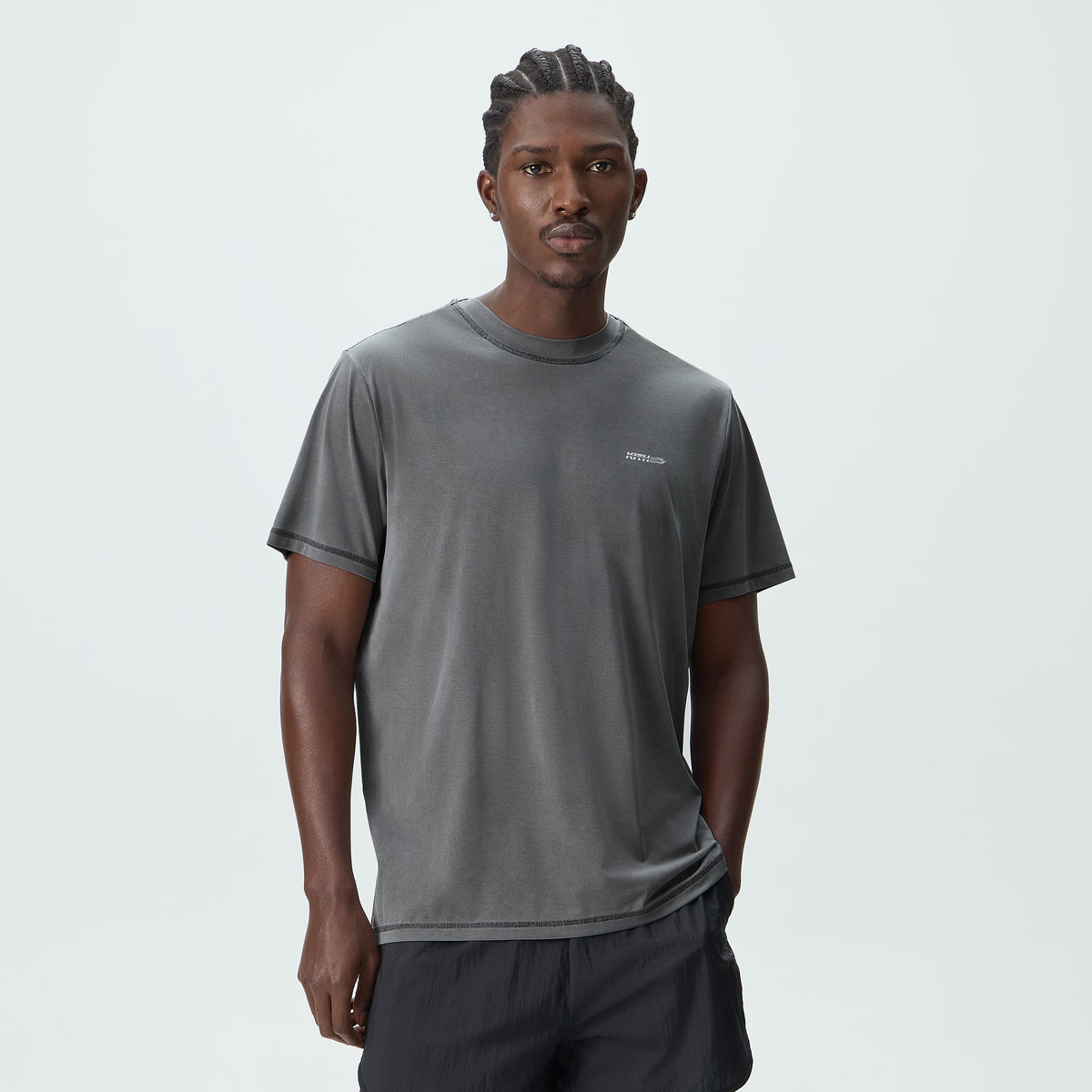 Man modeling Kith Garment-Dyed Heathrow Tee in shadow grey, relaxed fit crewneck