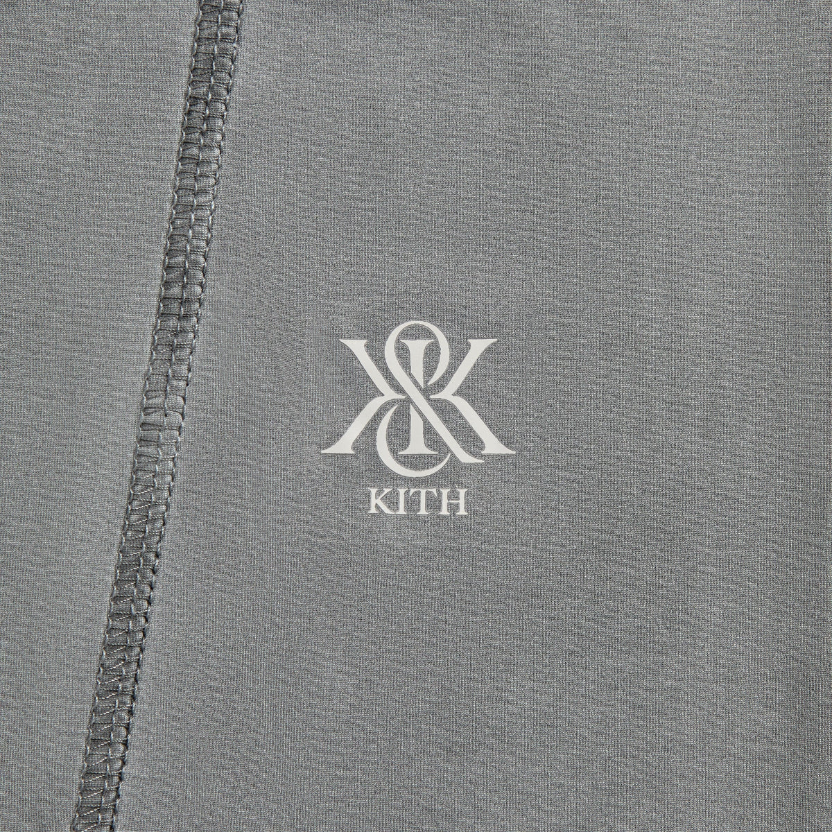 Man modeling Kith Garment-Dyed Paneled Donovan Tee in shadow grey, front view with black joggers