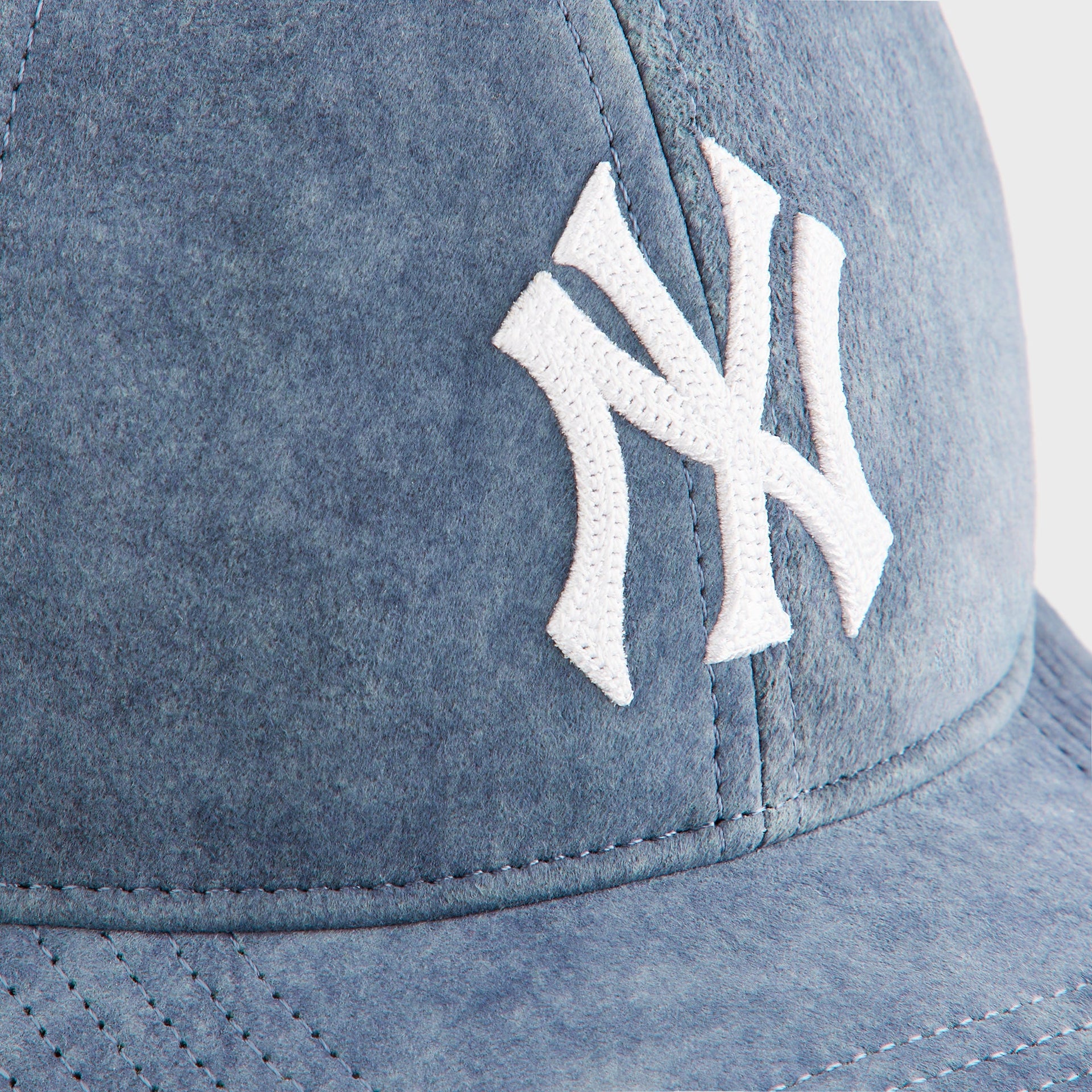 Close-up detail of the embroidered white NY Yankees logo on the Kith & '47 Washed Suede Franchise Cap in Torpedo