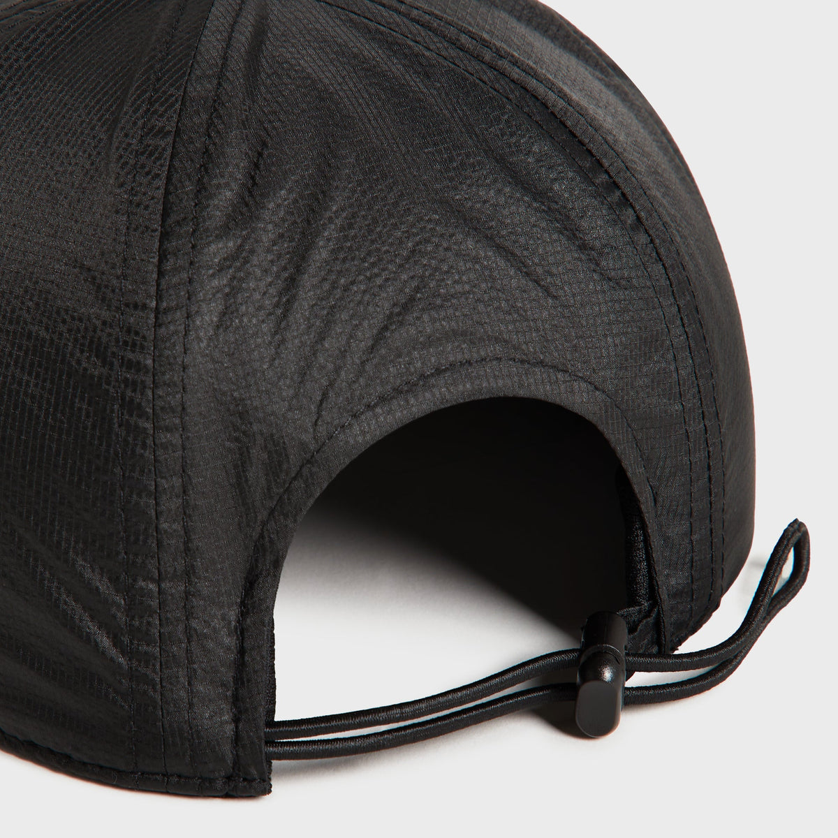 Close-up of the rear toggle cord adjuster on the Kith Nylon Ripstop Marathon Cap