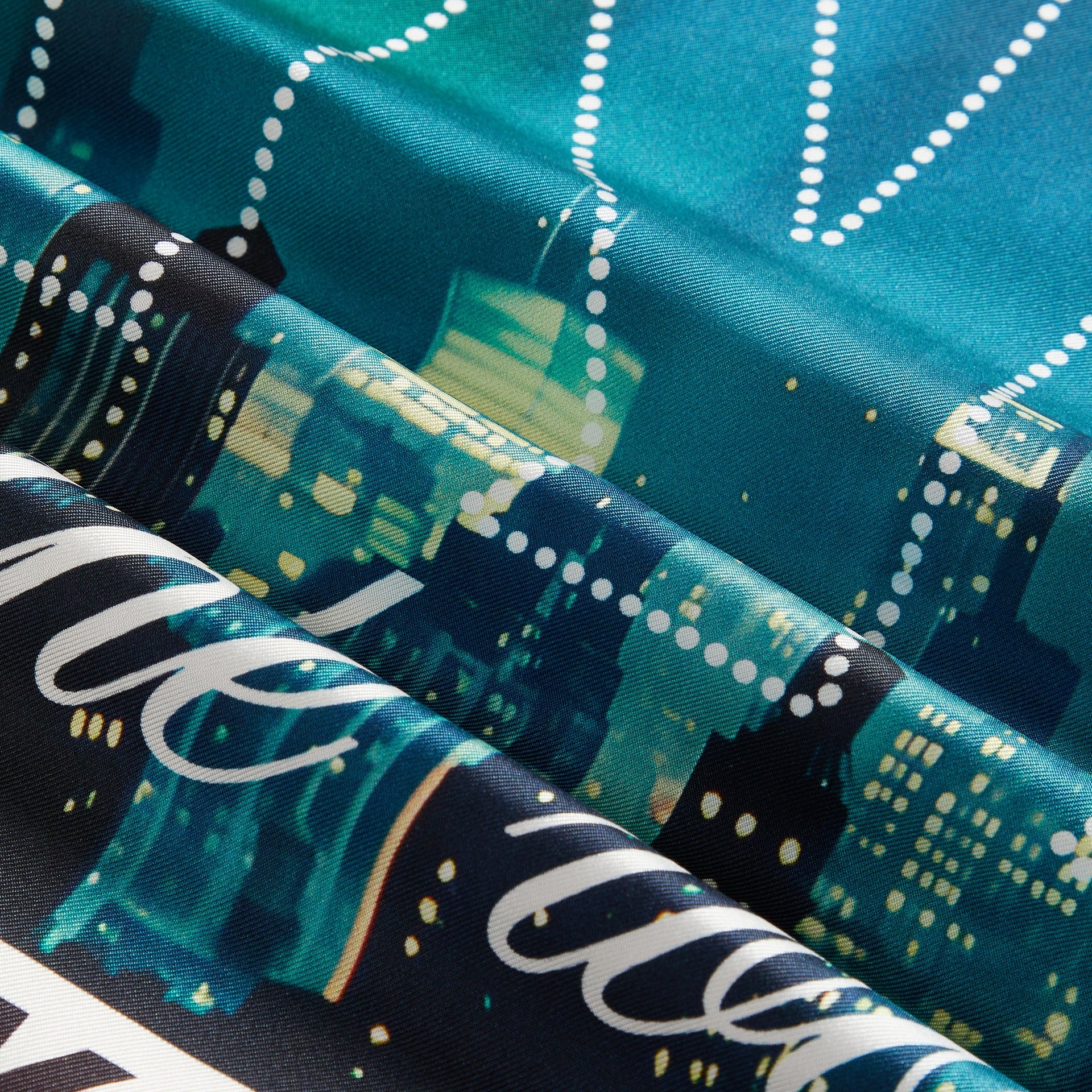 Close-up detail of Kith Silk Bandana in Multi showing folded silk, skyline print and dotted trim