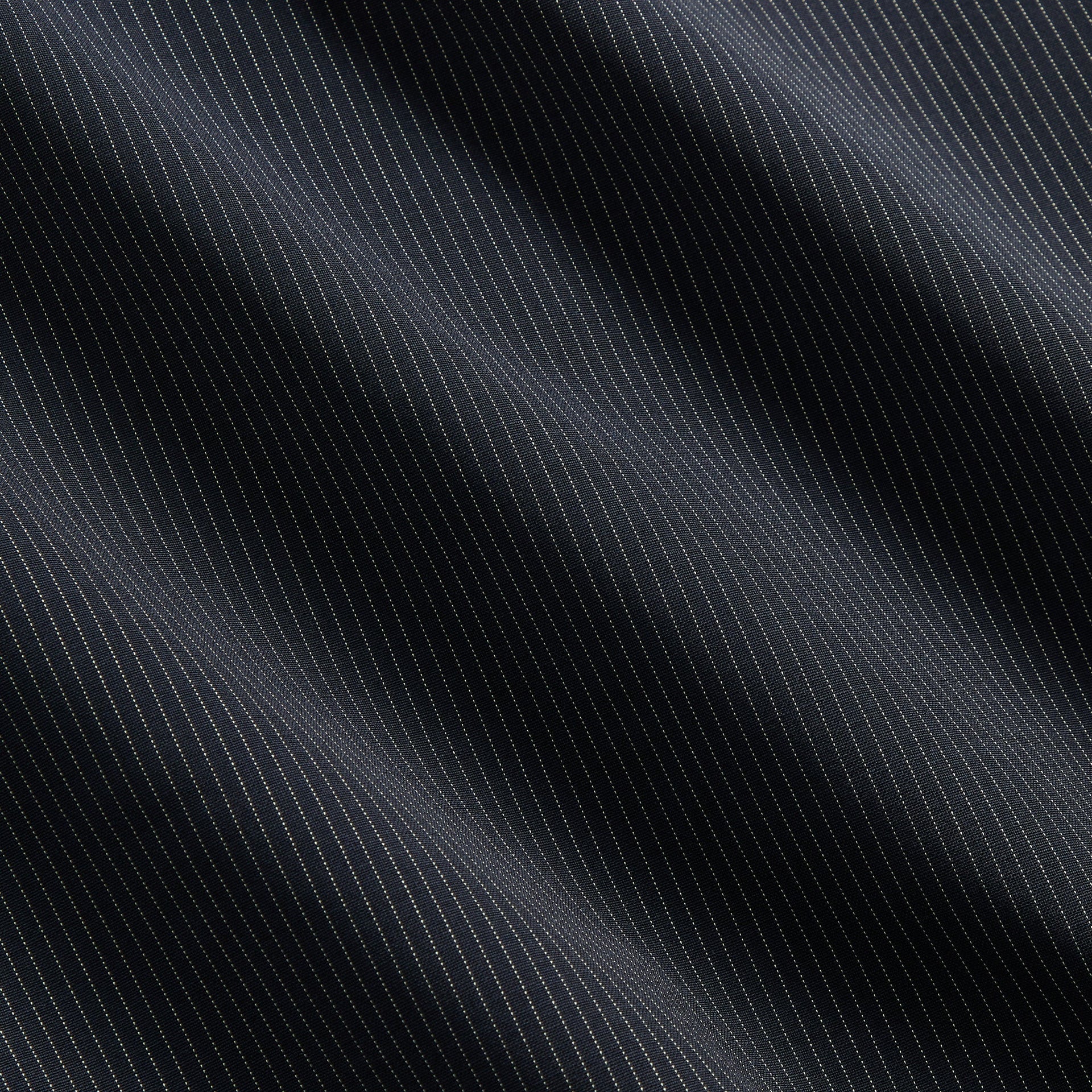 Close-up of Nocturnal navy pinstripe tropical wool fabric of the &Kin Gael Parka
