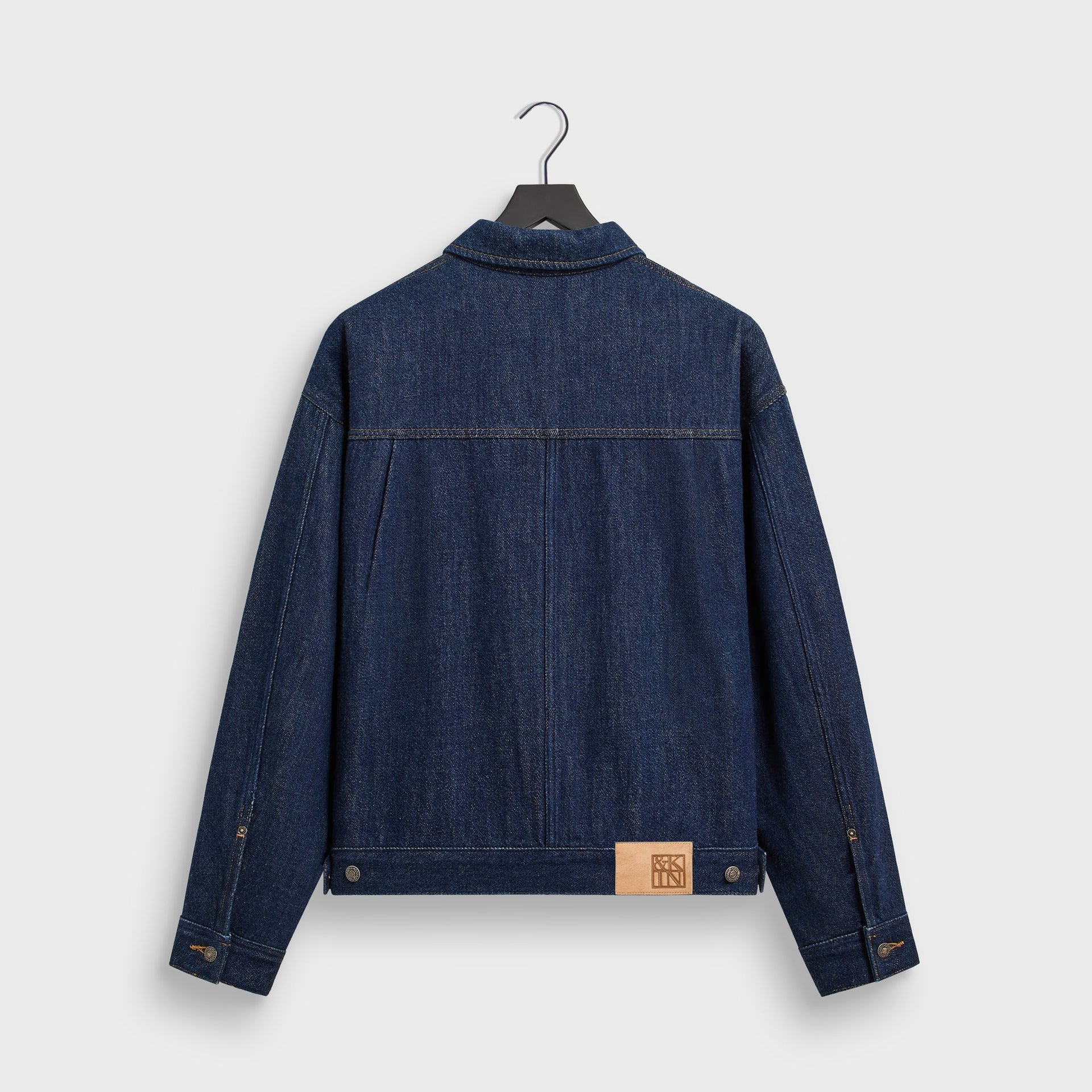 &Kin Rope Twill Alonzo Jacket in Dark Indigo, back view on hanger with leather &Kin patch at hem