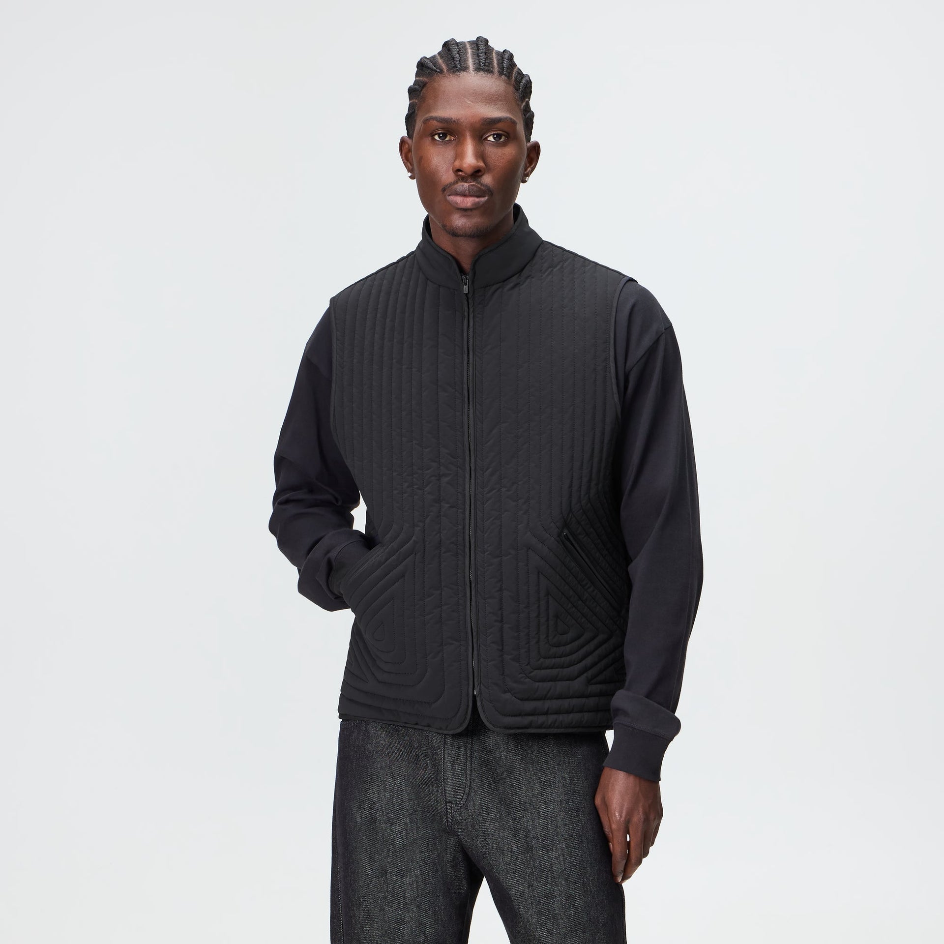 Man wearing the Kith Quilted Nylon Lorenzo vest in black over a black long sleeve top