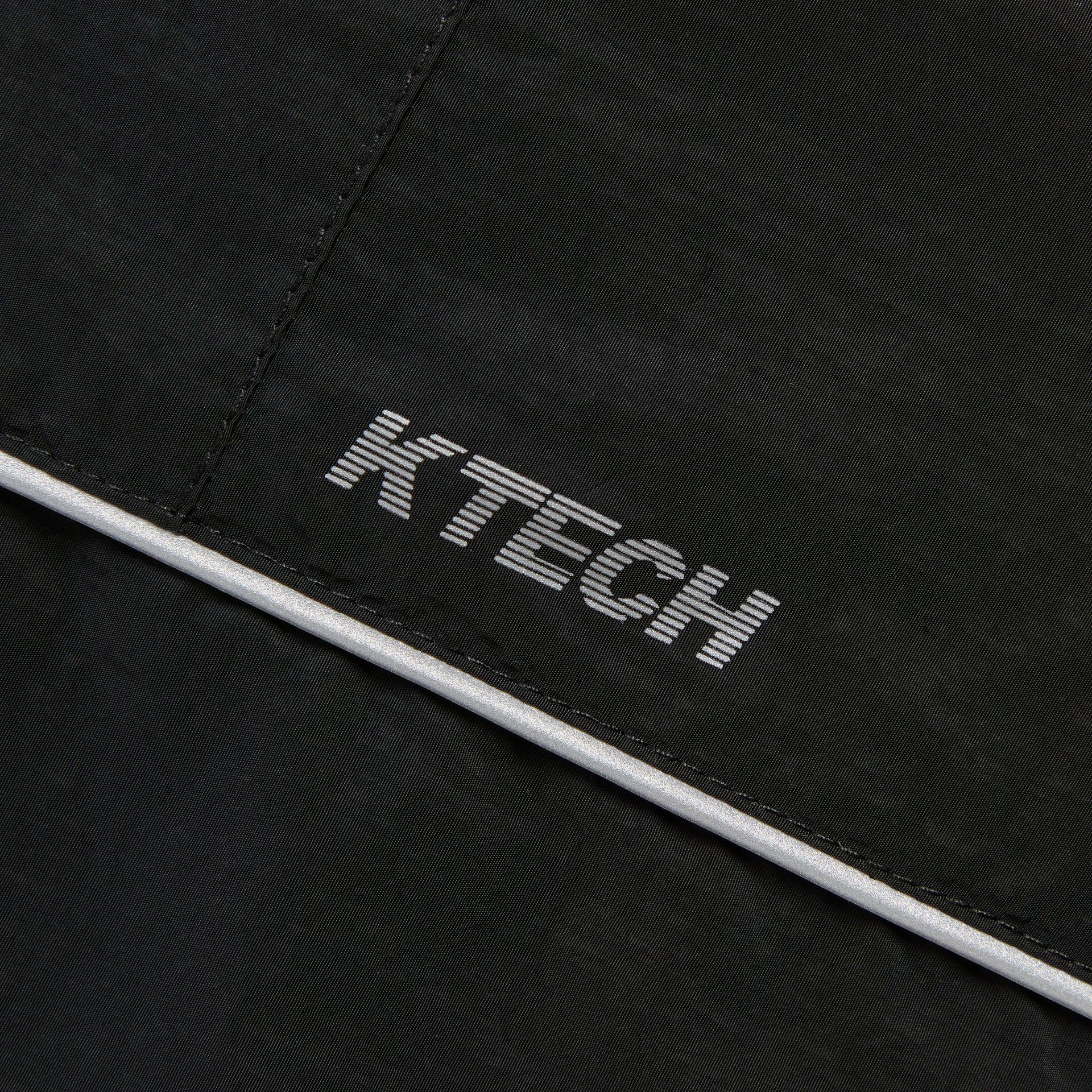 Close-up of the reflective KTECH logo piping on the Kith Nylon Bolt shell jacket