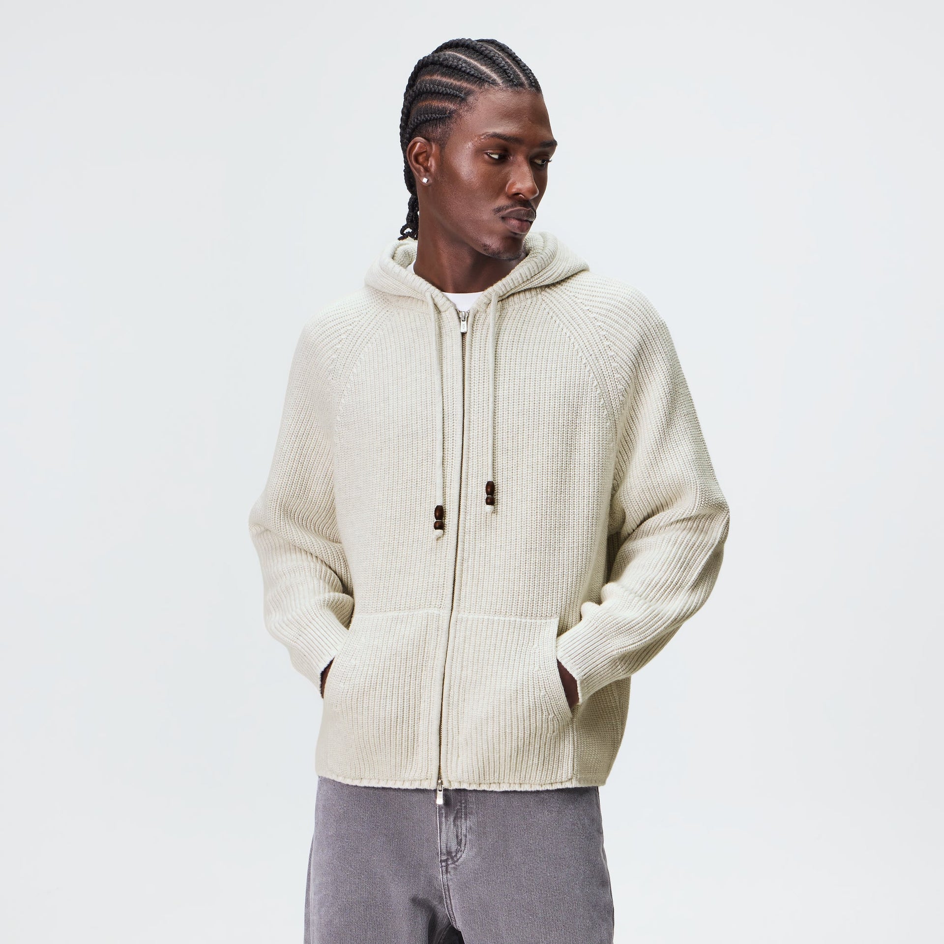 Man wearing the Kith Full Zip Knit Miles hoodie in light heather grey with grey denim