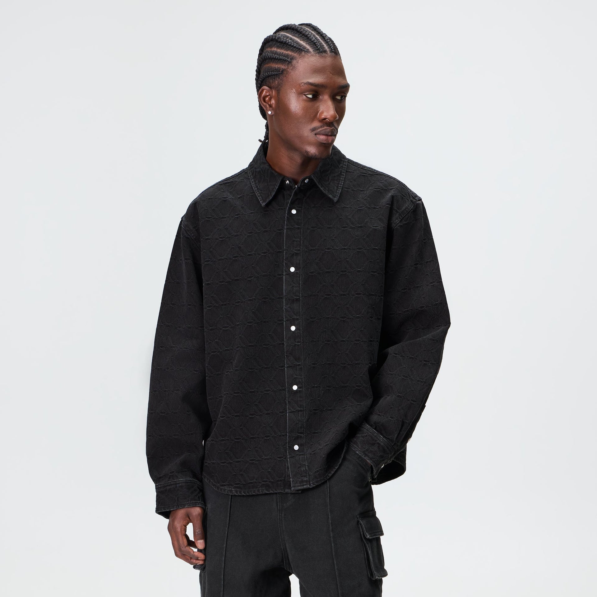 Man wearing the Kith Jacquard Crest Apollo shirt in black denim with matching cargo trousers
