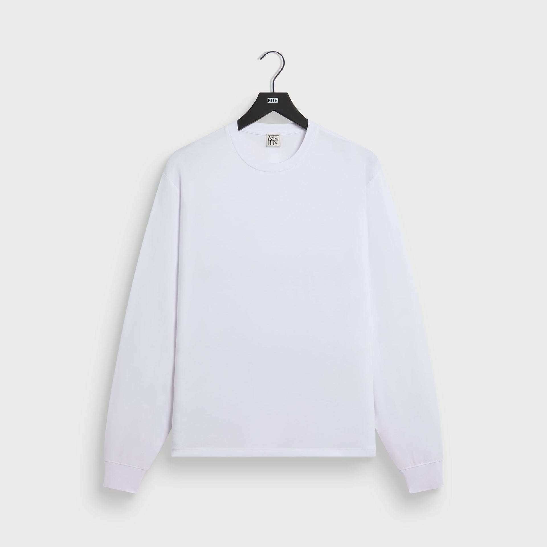 &Kin Long Sleeve Darin Tee in white, front view on KITH hanger with crewneck and ribbed cuffs