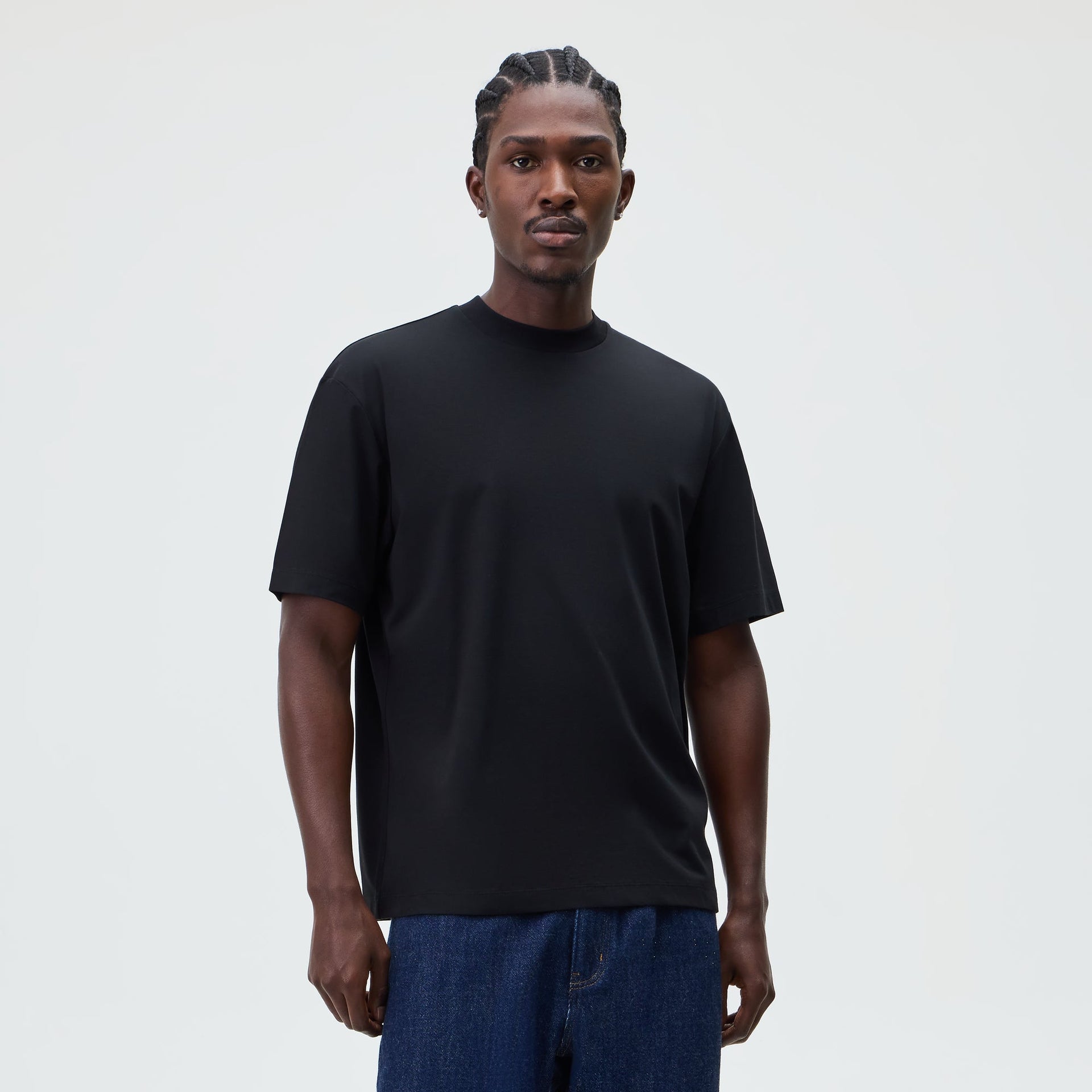 &Kin Mock Neck Albie Tee in black worn by a model with dark denim jeans, front view