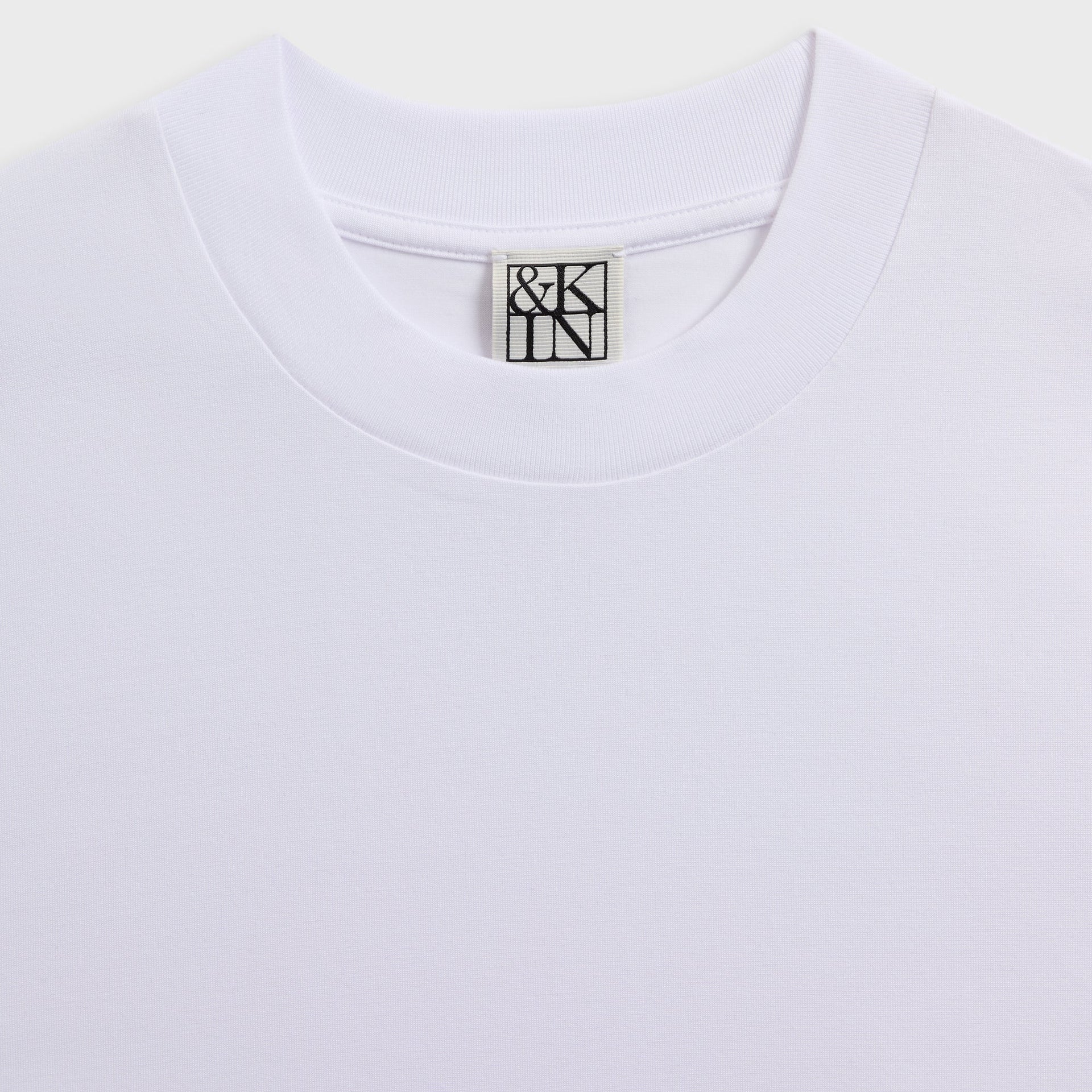 &Kin Albie Tee detail, ribbed white mock neck collar with woven &Kin logo label