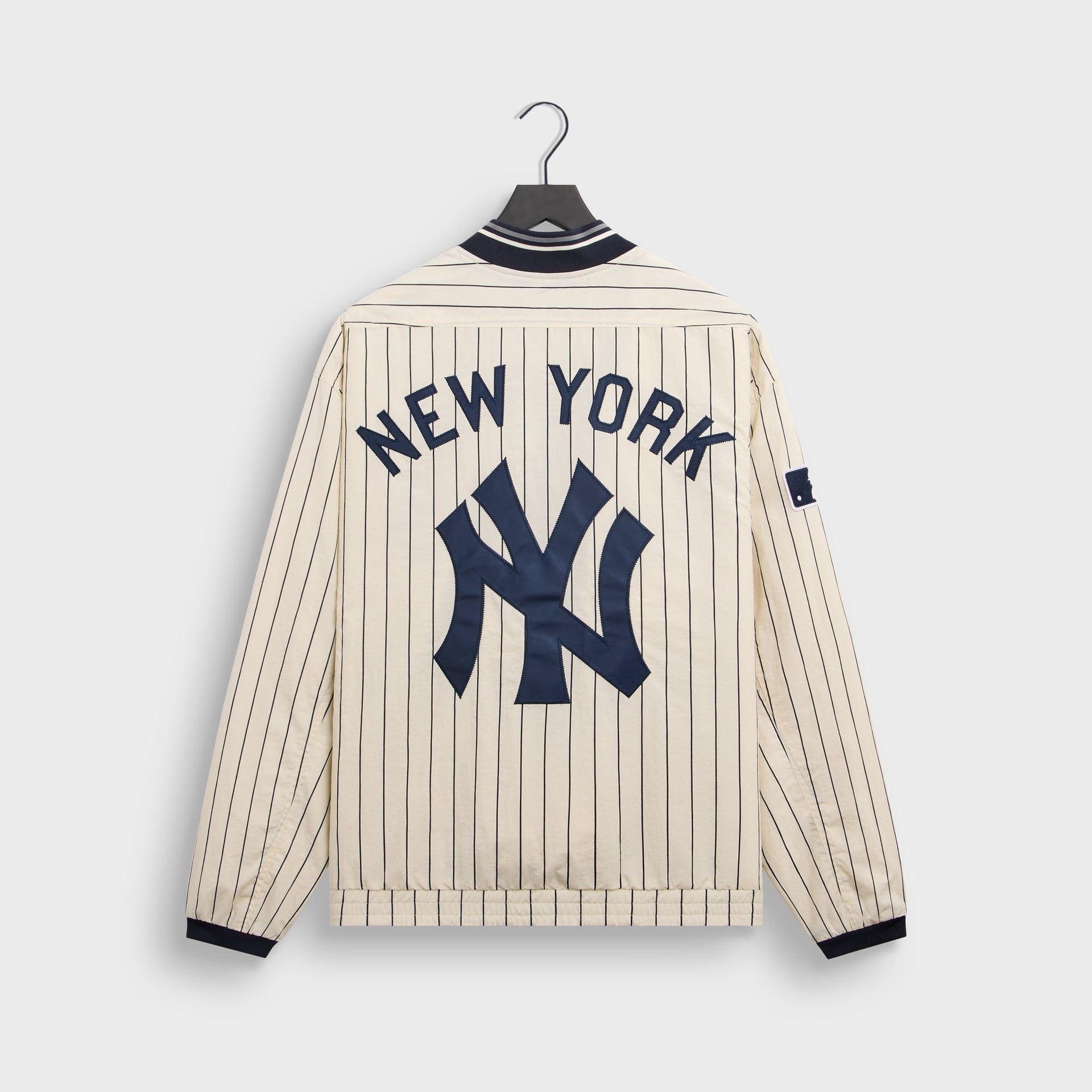 Back flat lay of cream Sandrift Nylon Raffi pullover with New York and NY logo appliqué