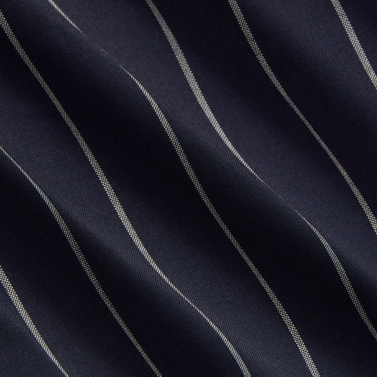 Close-up of navy pinstripe tropical wool fabric texture on the Raffi pullover
