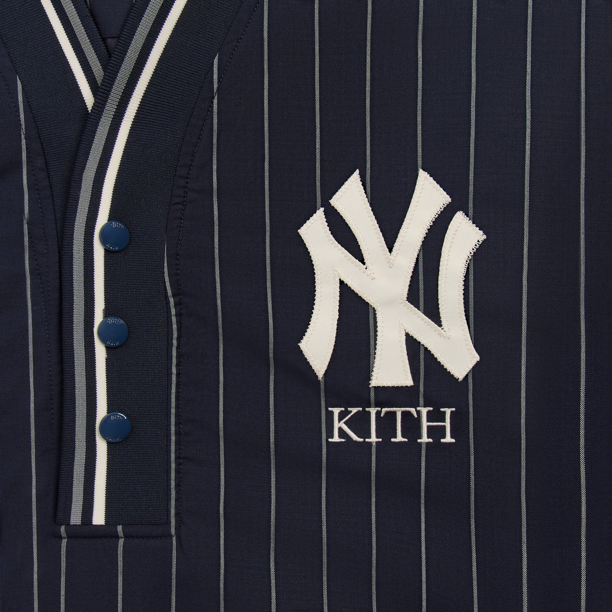 Close-up of NY Yankees and Kith embroidered logo on navy pinstripe Raffi pullover placket