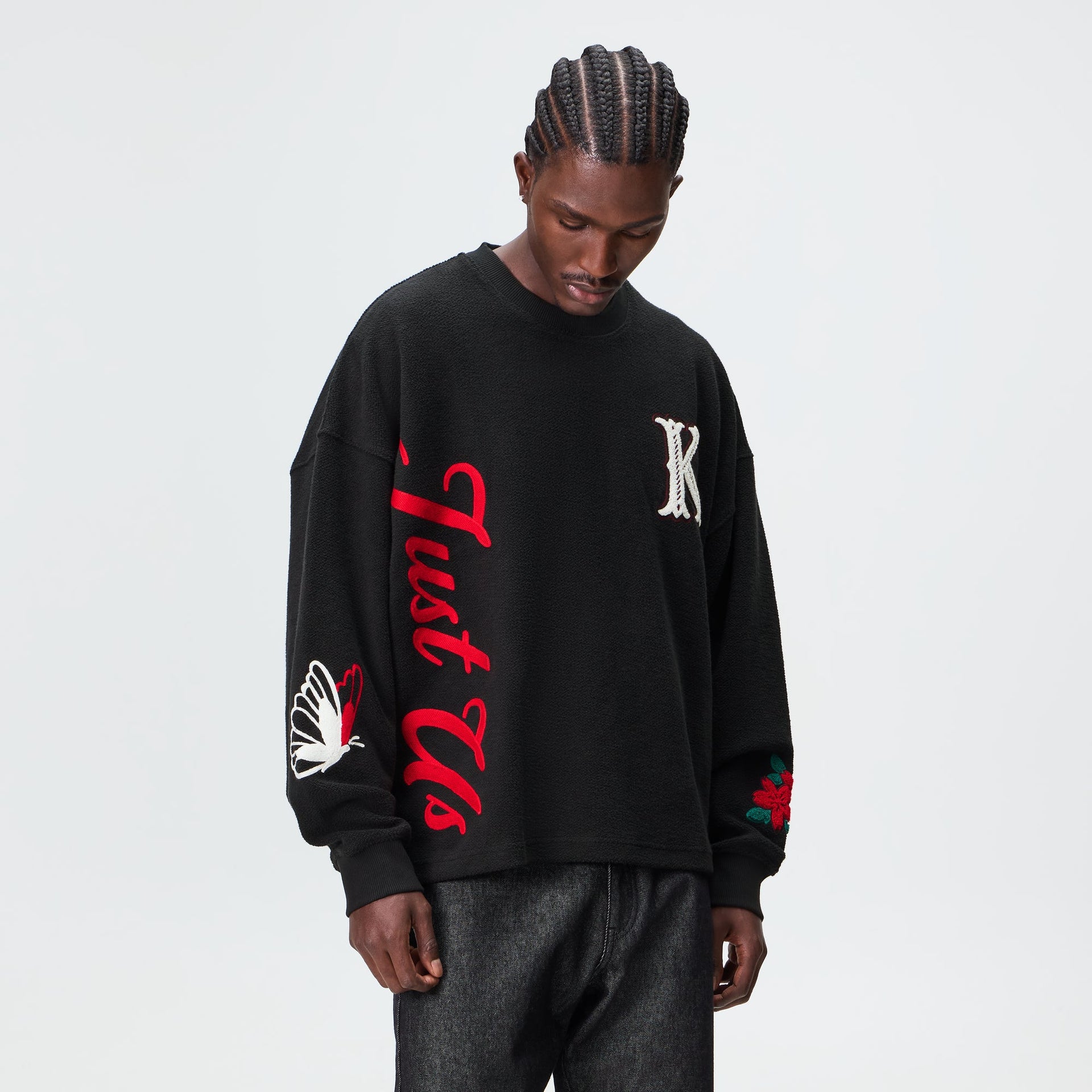 Man wearing the Kith Varsity Lawson crewneck in black with chenille K patch, front view