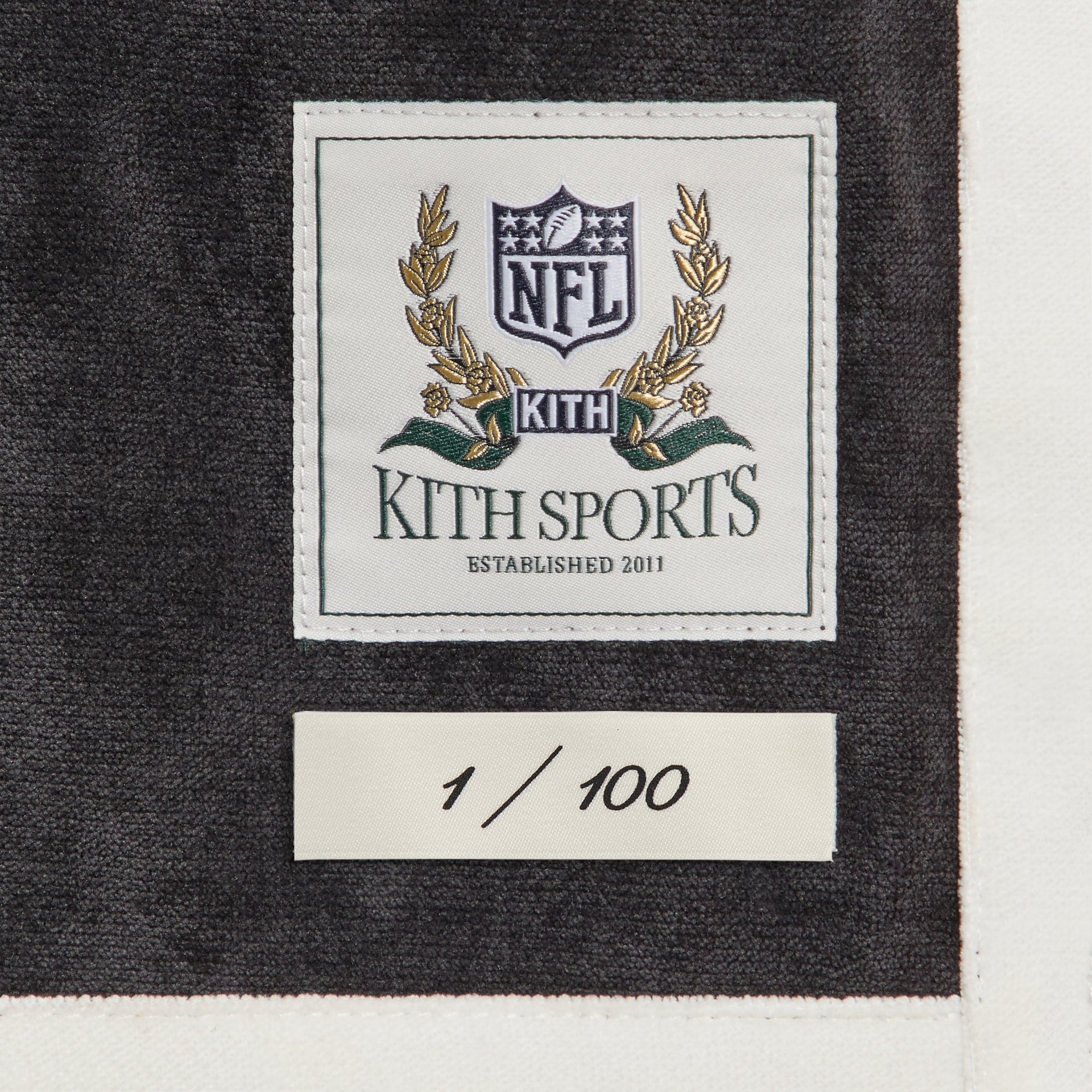 Close-up of the Kith Sports NFL woven label and 1 of 100 numbering tag on the Steelers Leon shirt