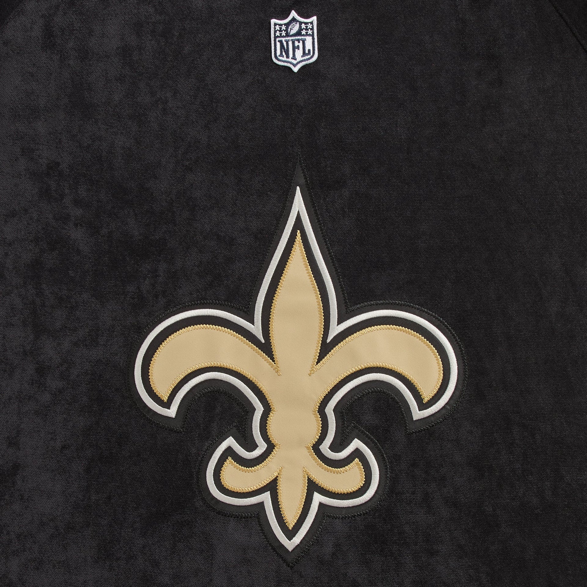Close-up of the New Orleans Saints fleur-de-lis logo patch on the Kith NFL Leon shirt