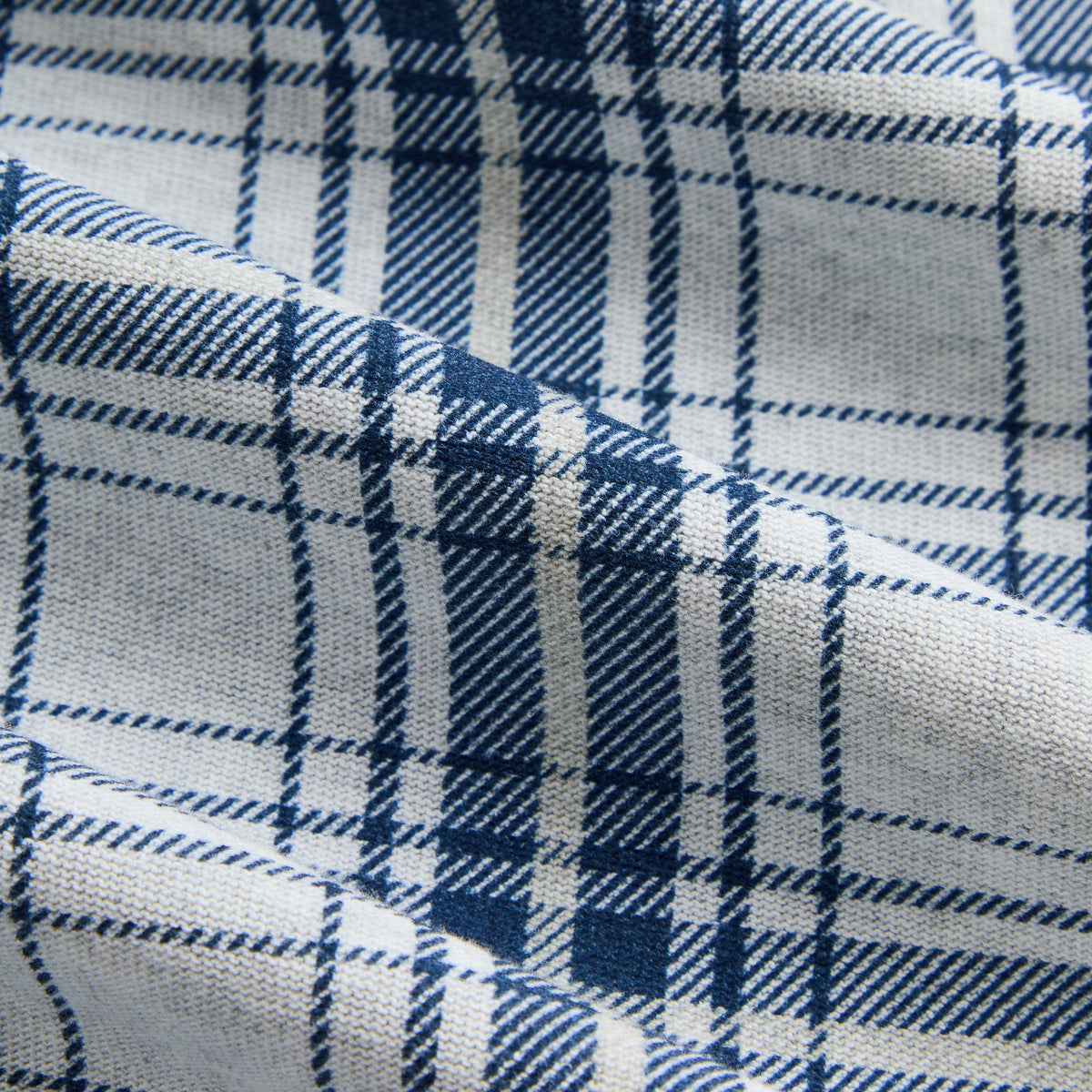 Close-up of the blue and white plaid jersey fabric of the Kith Kurt quarter-zip