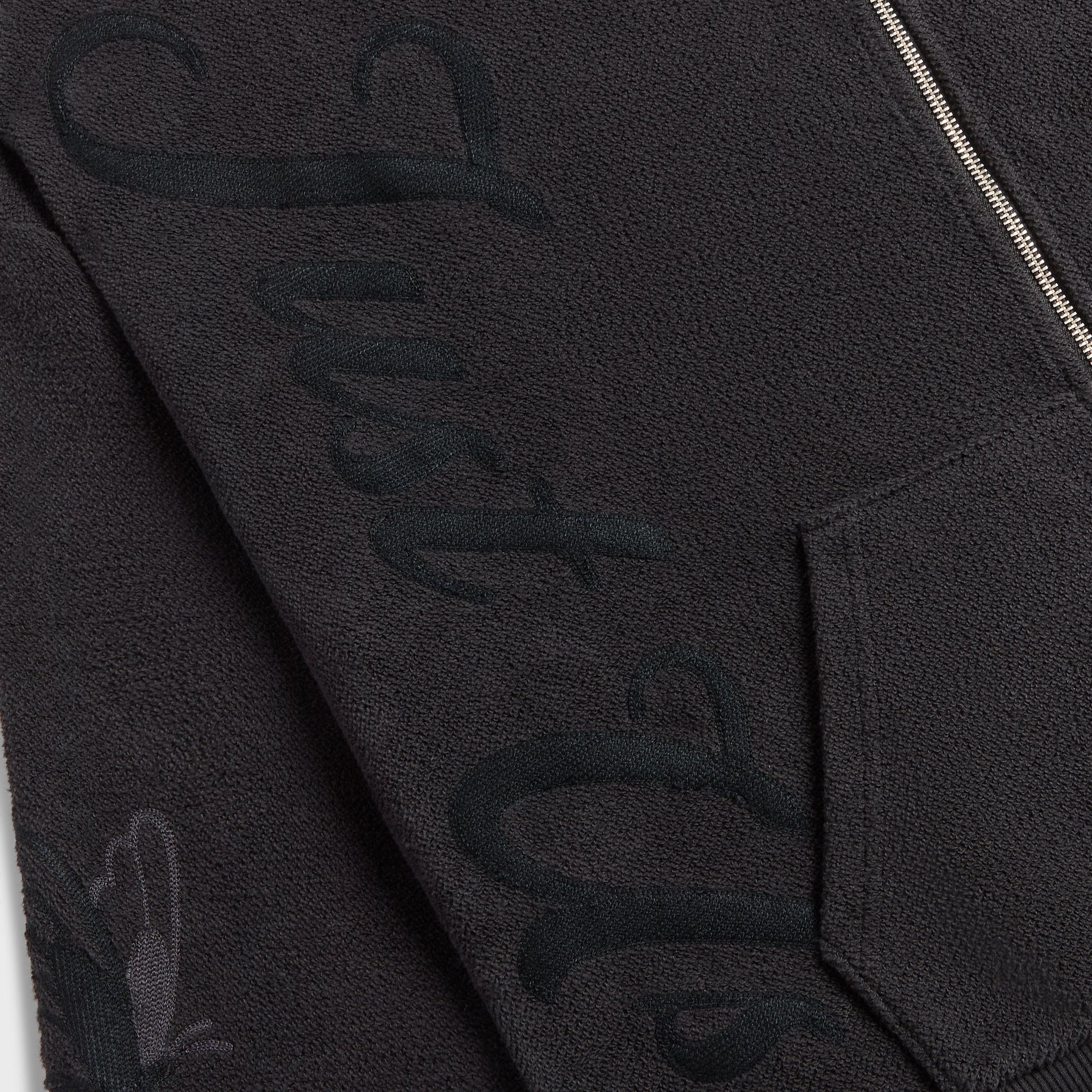 Close-up of the tonal embroidered script lettering on the Kith Varsity Braxton hoodie sleeve