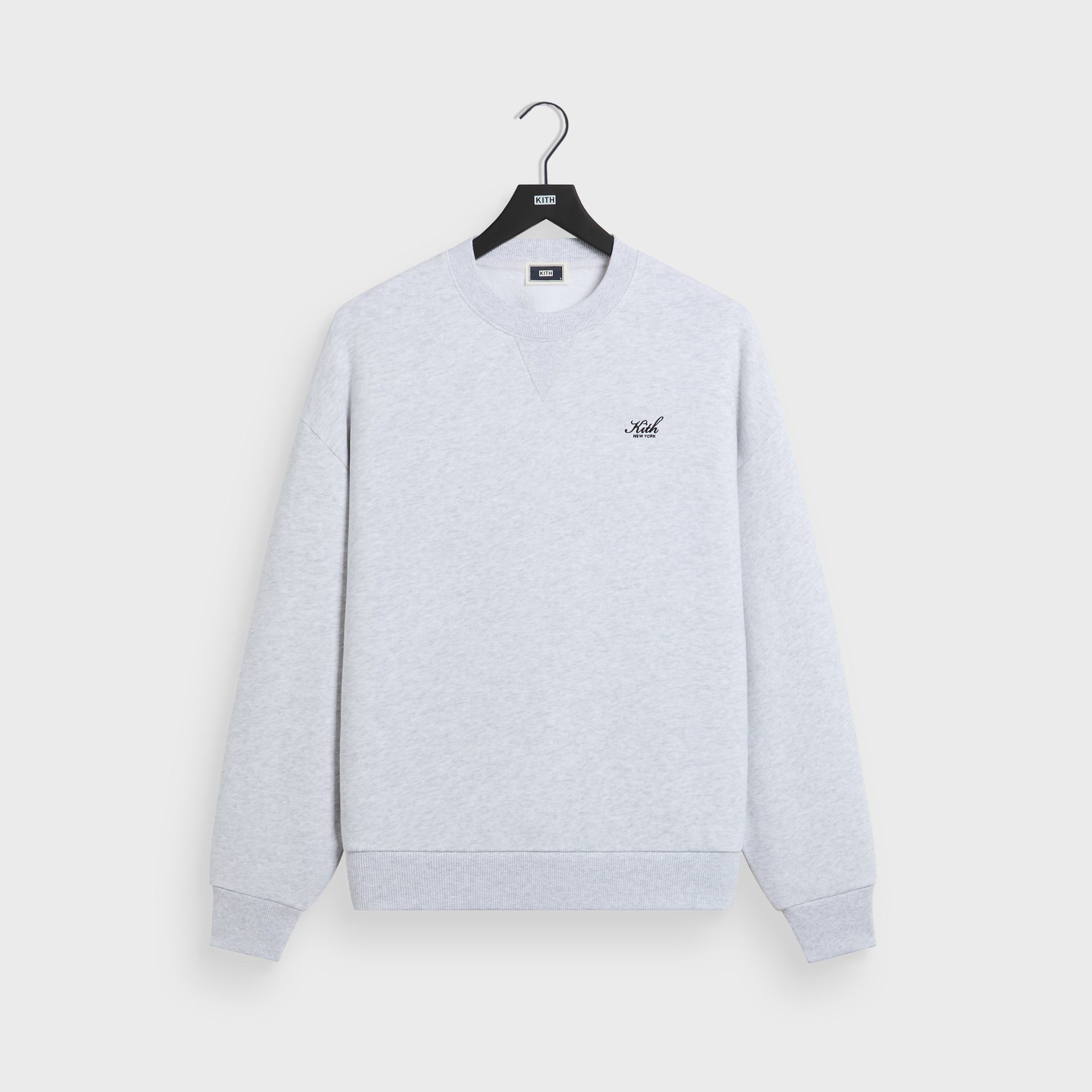 Kith Nelson crewneck in light heather grey cotton fleece, front flat lay on hanger