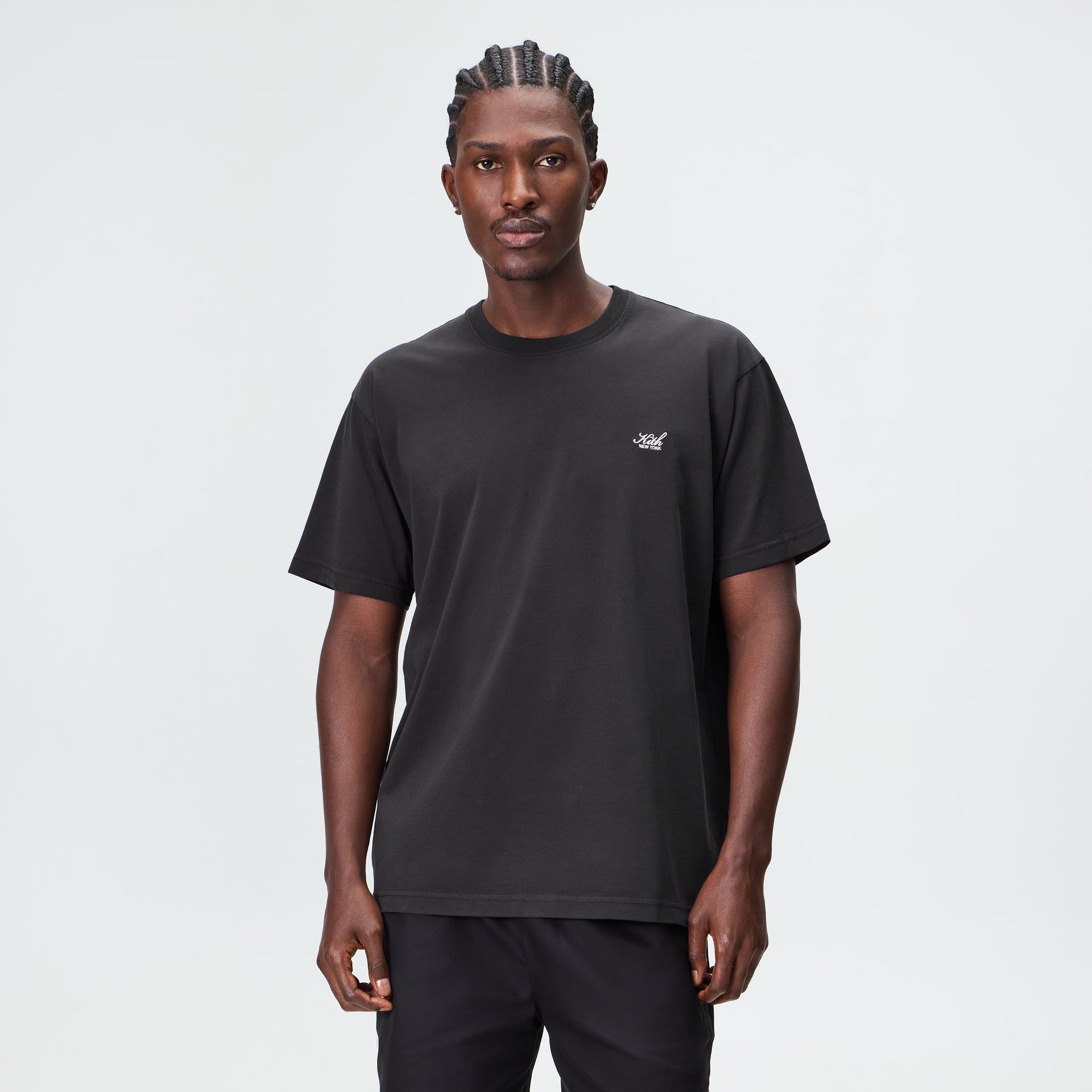 Man wearing the Kith LAX tee in black cotton with small crest chest logo
