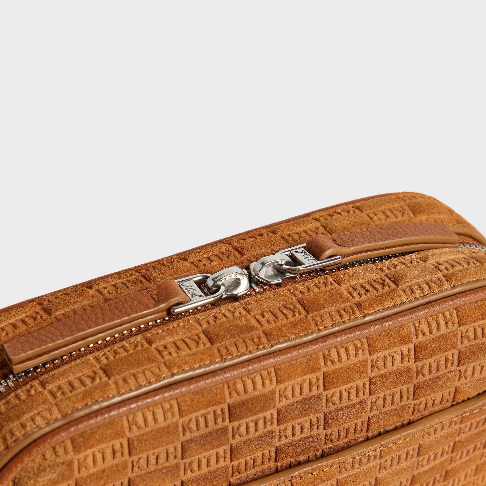 Close-up of zipper pull and Kith branded hardware on Crosswalk K20 Bag in Argil suede
