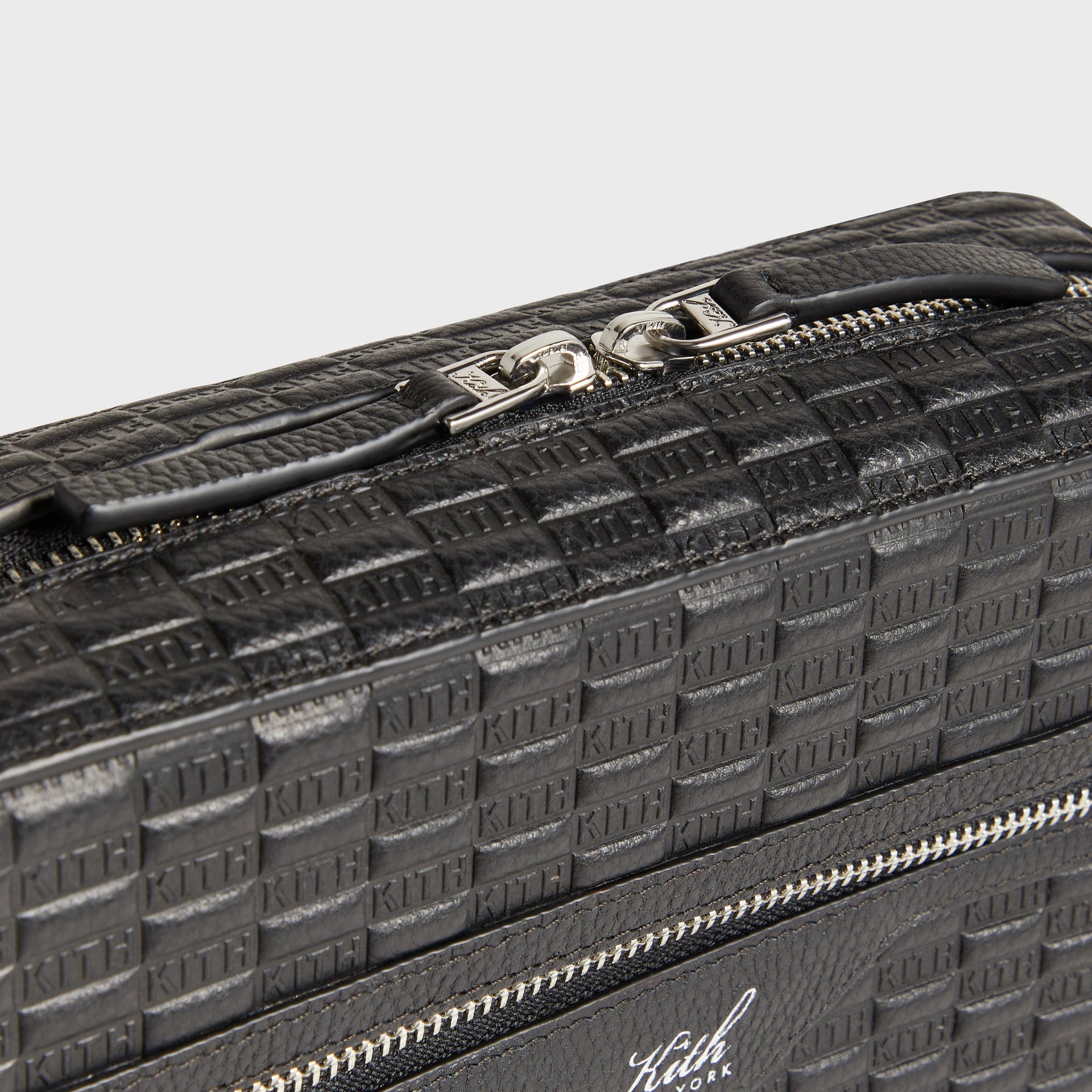 Close-up of zipper pull and top hardware on Kith Camera Crossbody Bag in Black leather