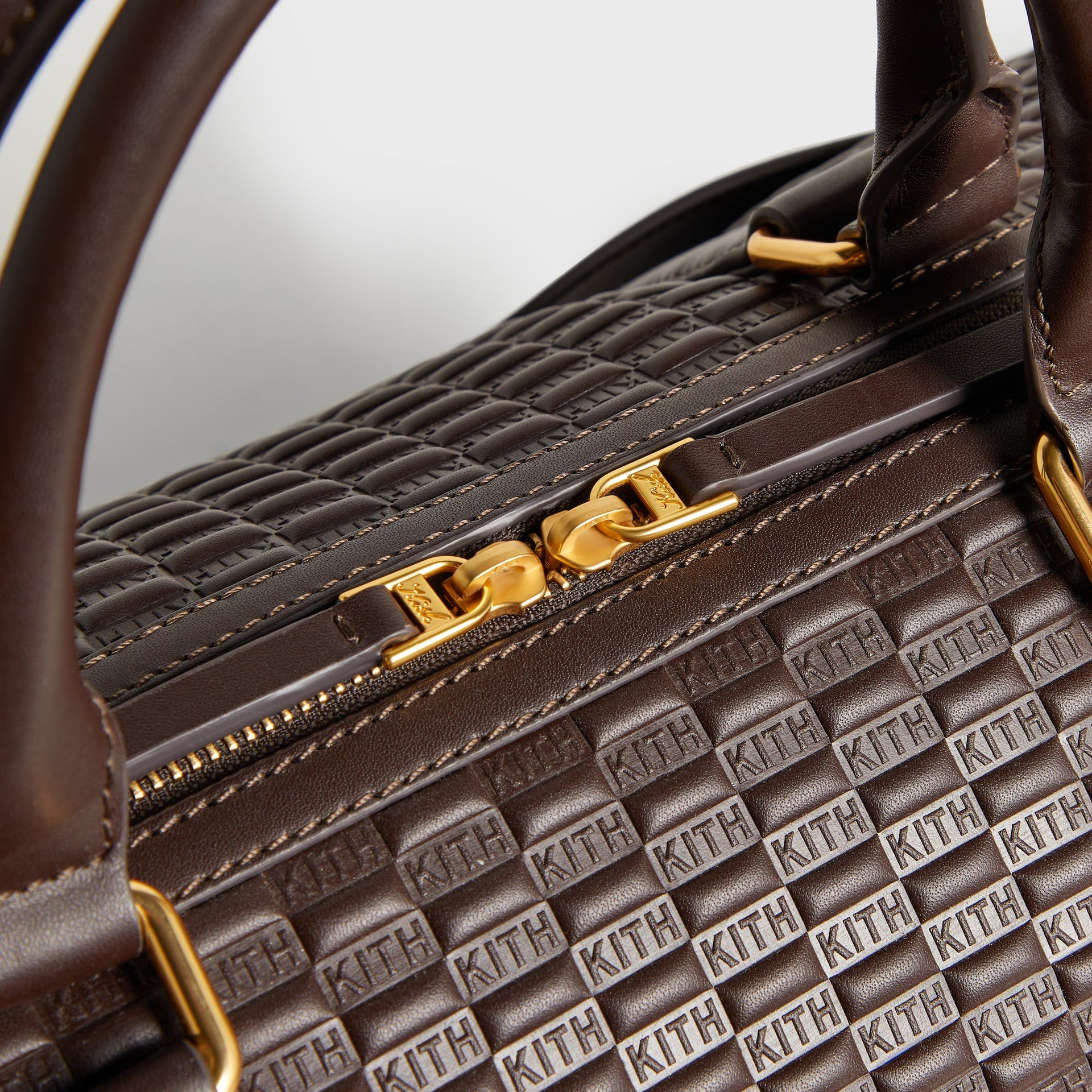 Close-up of top handle stitching and gold zipper pull on the Kith Traveler K40 Duffle Bag
