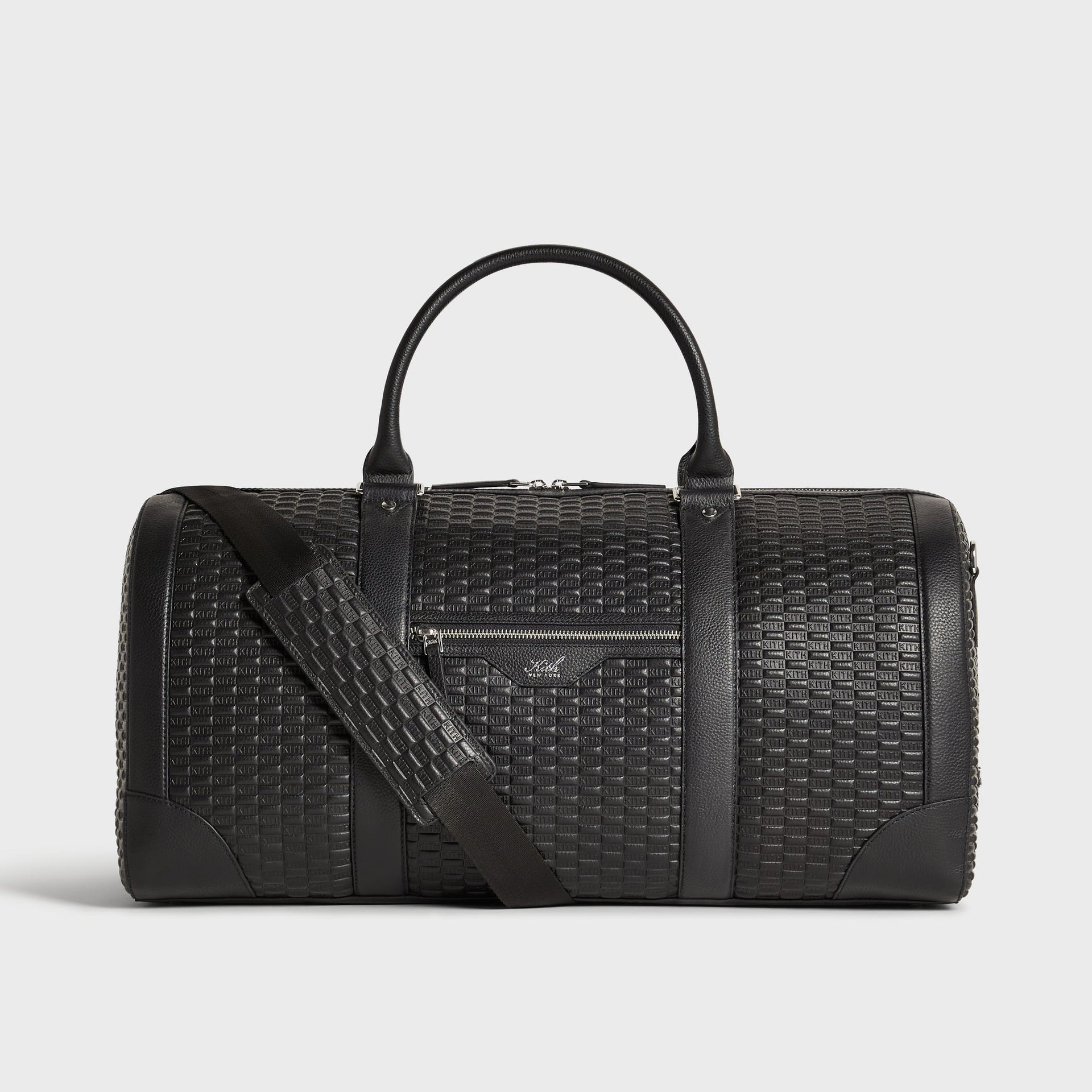 Kith Monogram Tumbled Leather Traveler K55 Duffle Bag in black, front view with top handles up and shoulder strap draped across the front pocket.