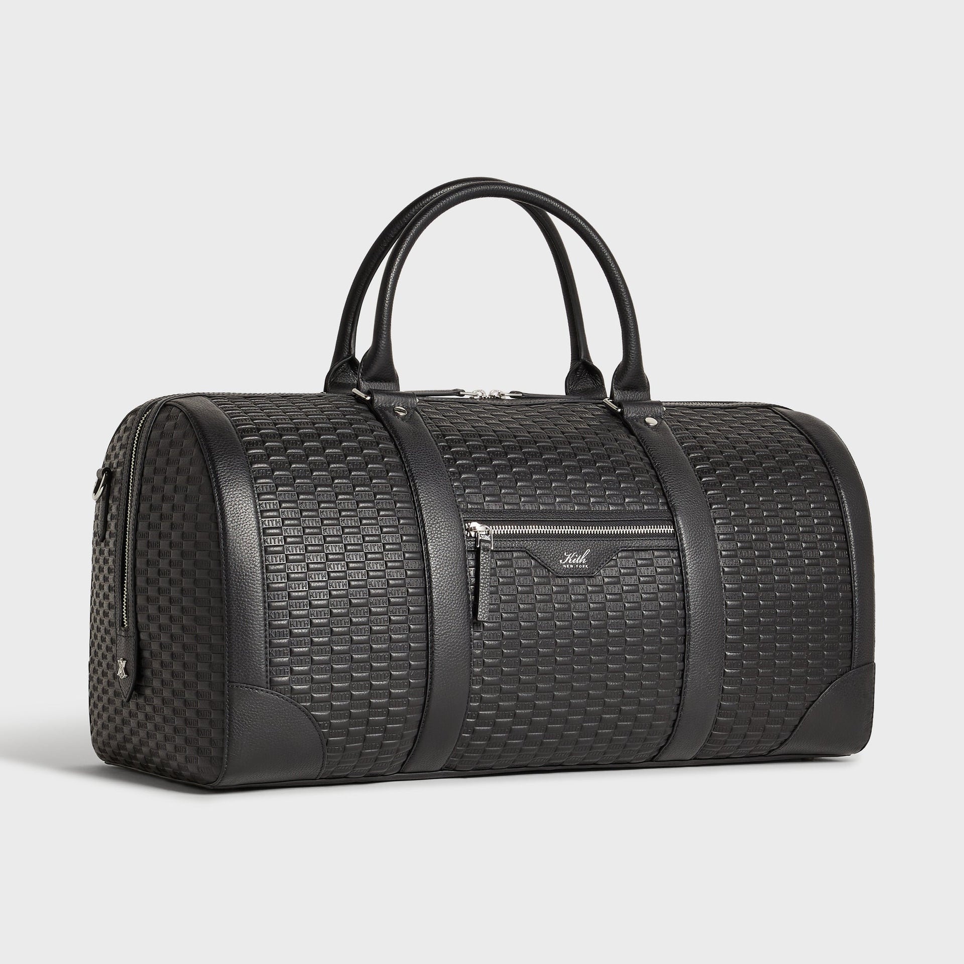 Kith Monogram Tumbled Leather Traveler K55 Duffle Bag in black, three-quarter angle view highlighting the front zip pocket with Kith New York logo.