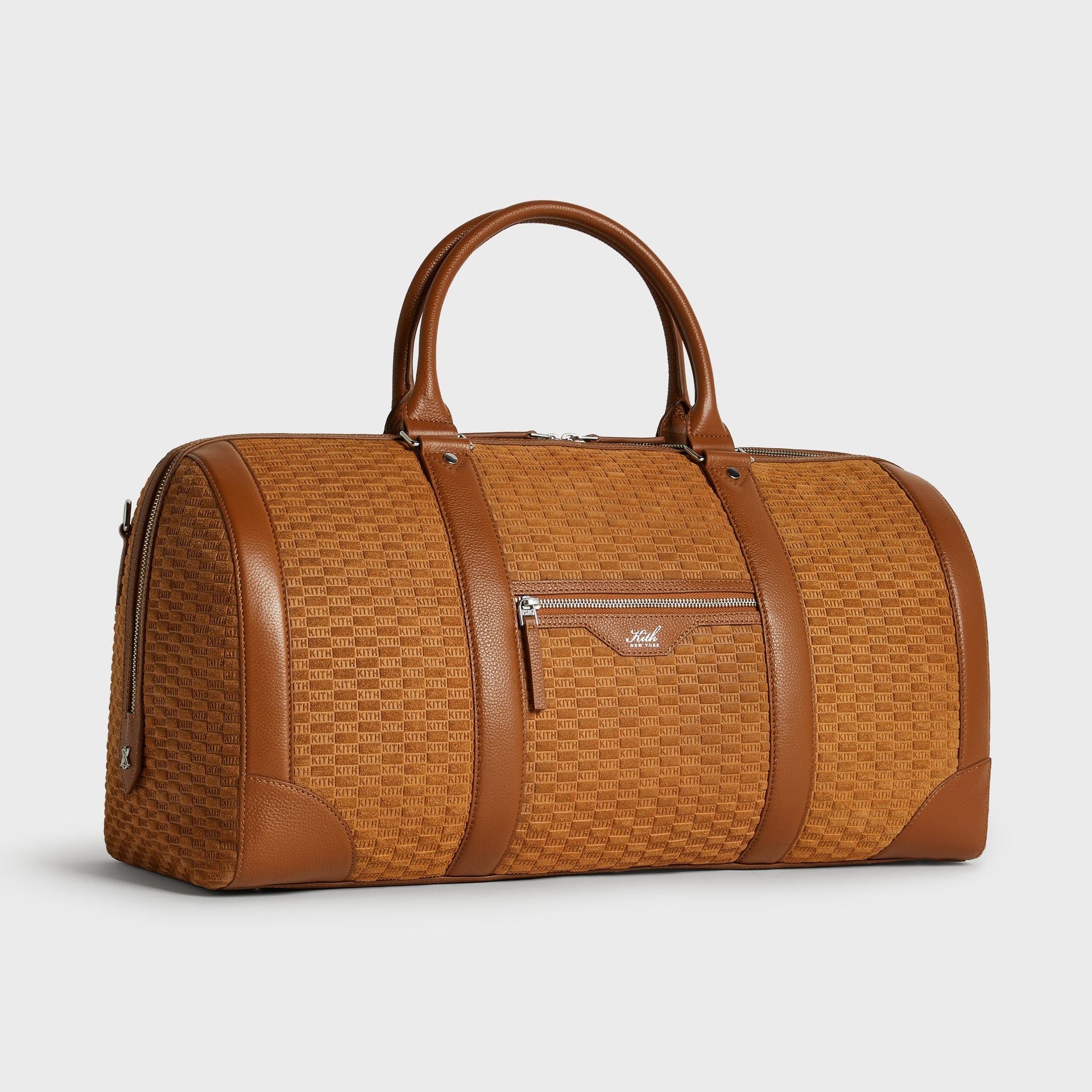 Kith Monogram Suede Traveler K55 Duffle Bag in Argil, three-quarter angle view showing rounded silhouette and side zip