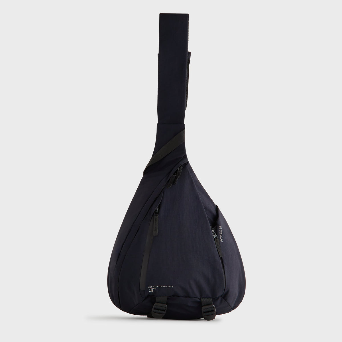Kith Nylon Ripstop Sling Backpack in navy black, back panel view showing the padded shoulder strap