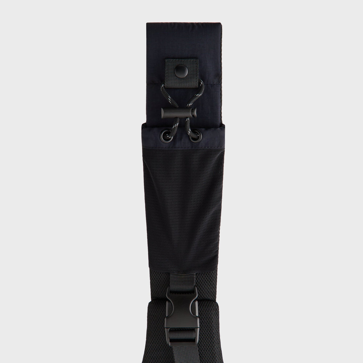 Close-up of the mesh strap panel, cinch cord, and clip buckle on the Kith sling backpack