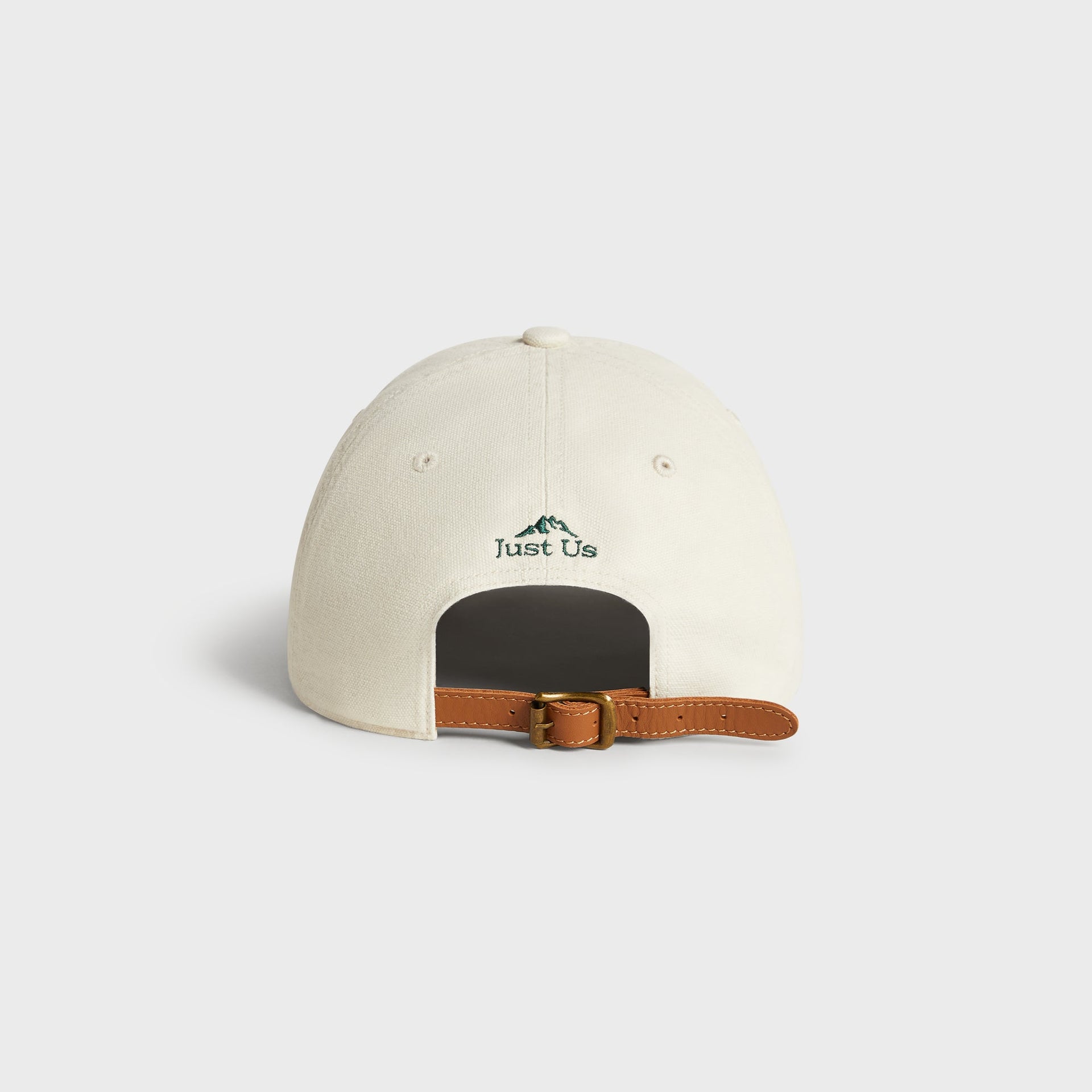 Back view of Kith & '47 Canvas cap in Sandrift showing 'Just Us' mountain logo and leather strap buckle