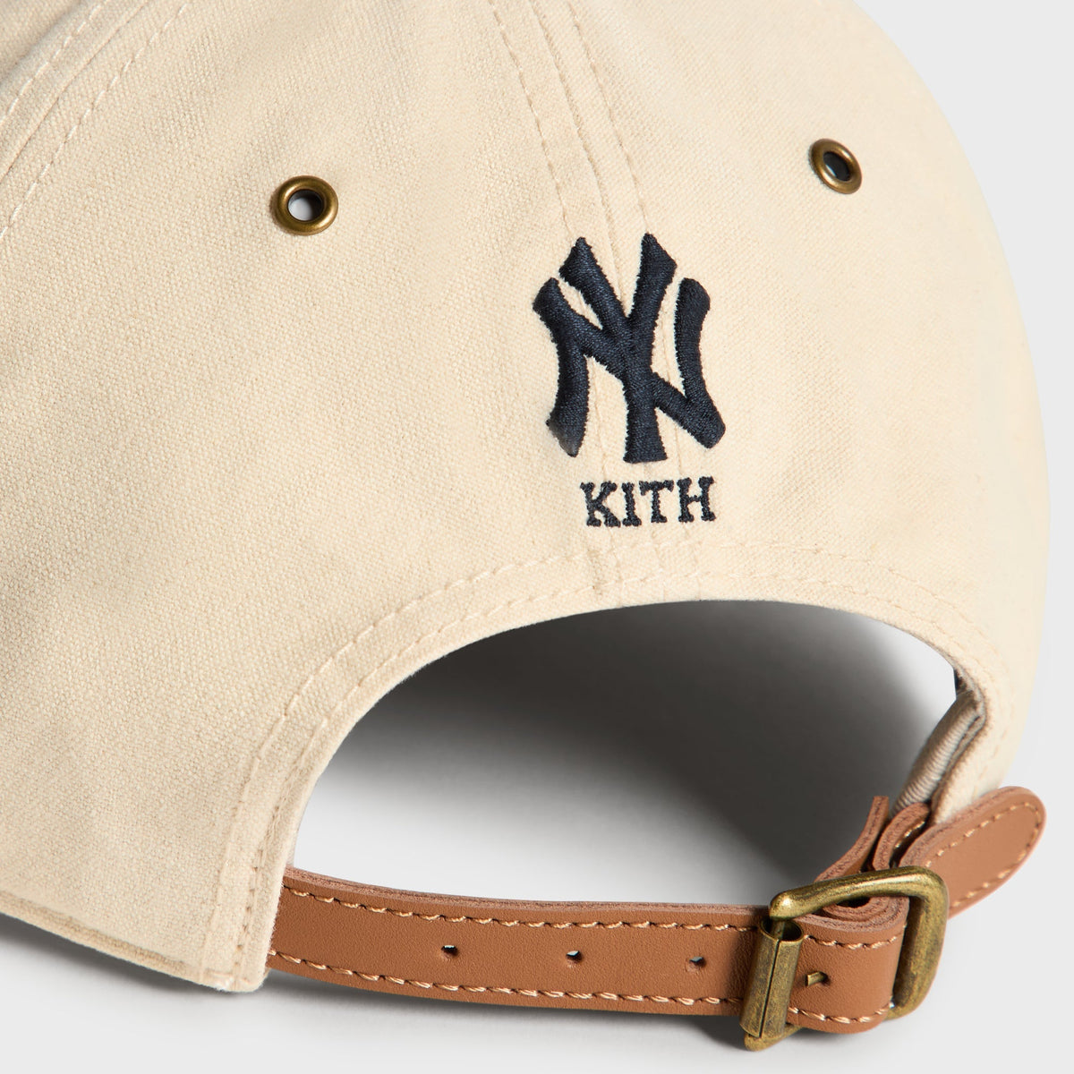 Close-up back detail of Sandrift Duck Canvas cap showing NY Kith logo and brass buckle strap