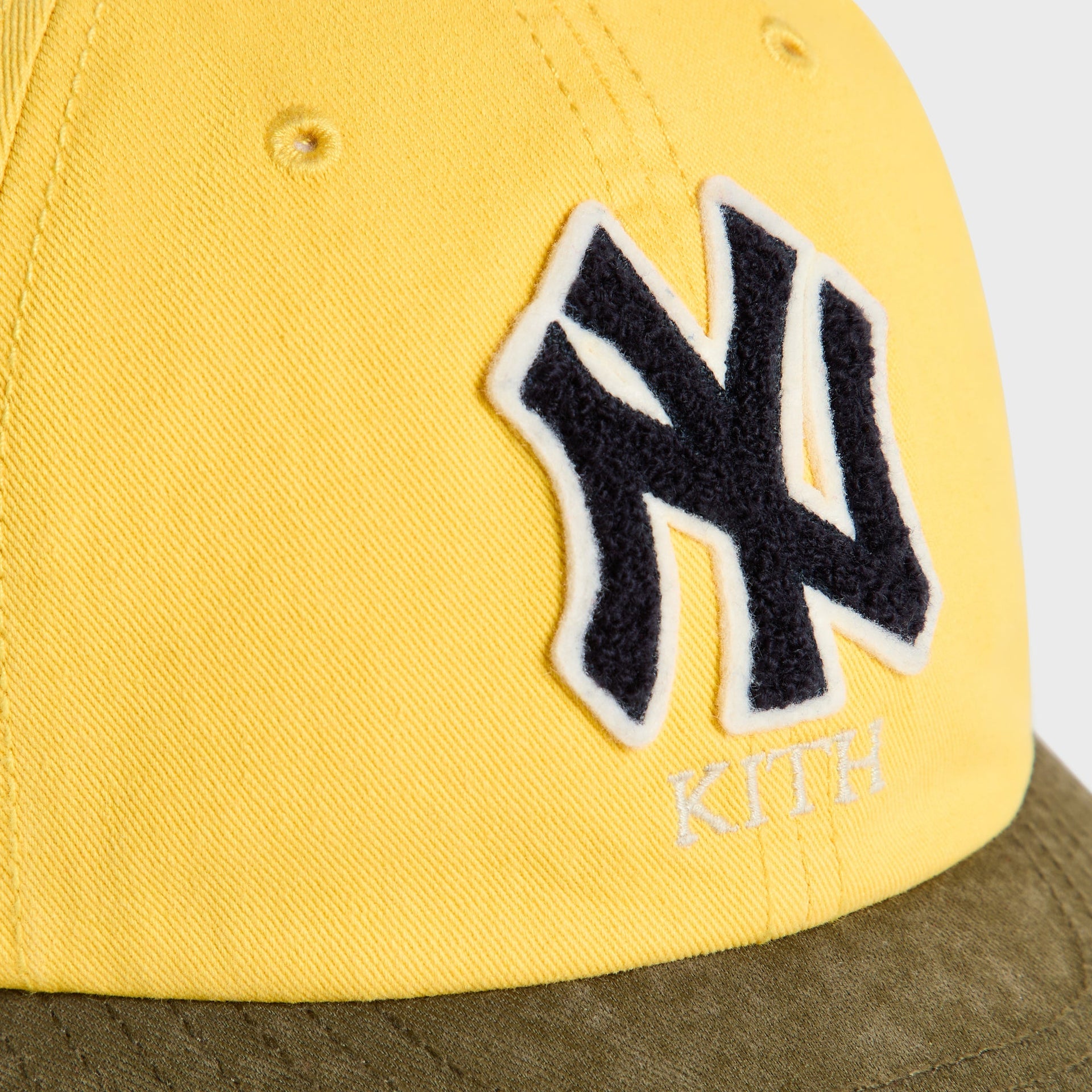 Close-up of NY chenille patch and Kith wordmark on Buzz Clean Up Round Visor Cap