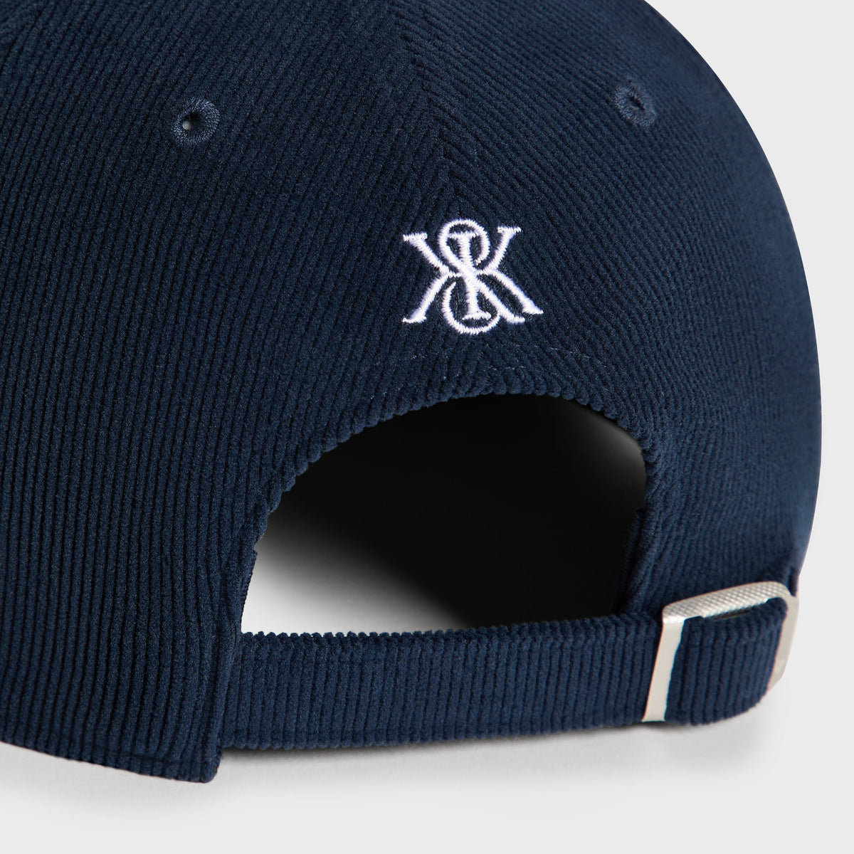 Close-up back detail of K monogram logo on Nocturnal Corduroy Curve Clean Up Cap
